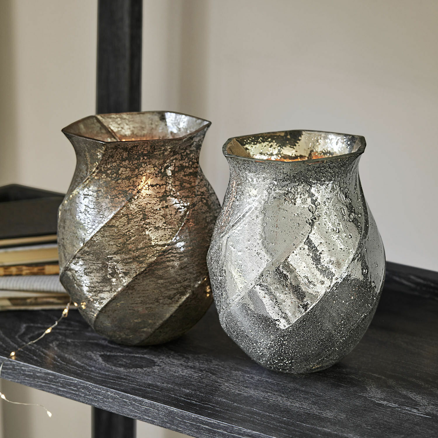 Coppia di portalumini Tixovel Due vasi decorativi in vetro color argento e oro con texture su mensola scura