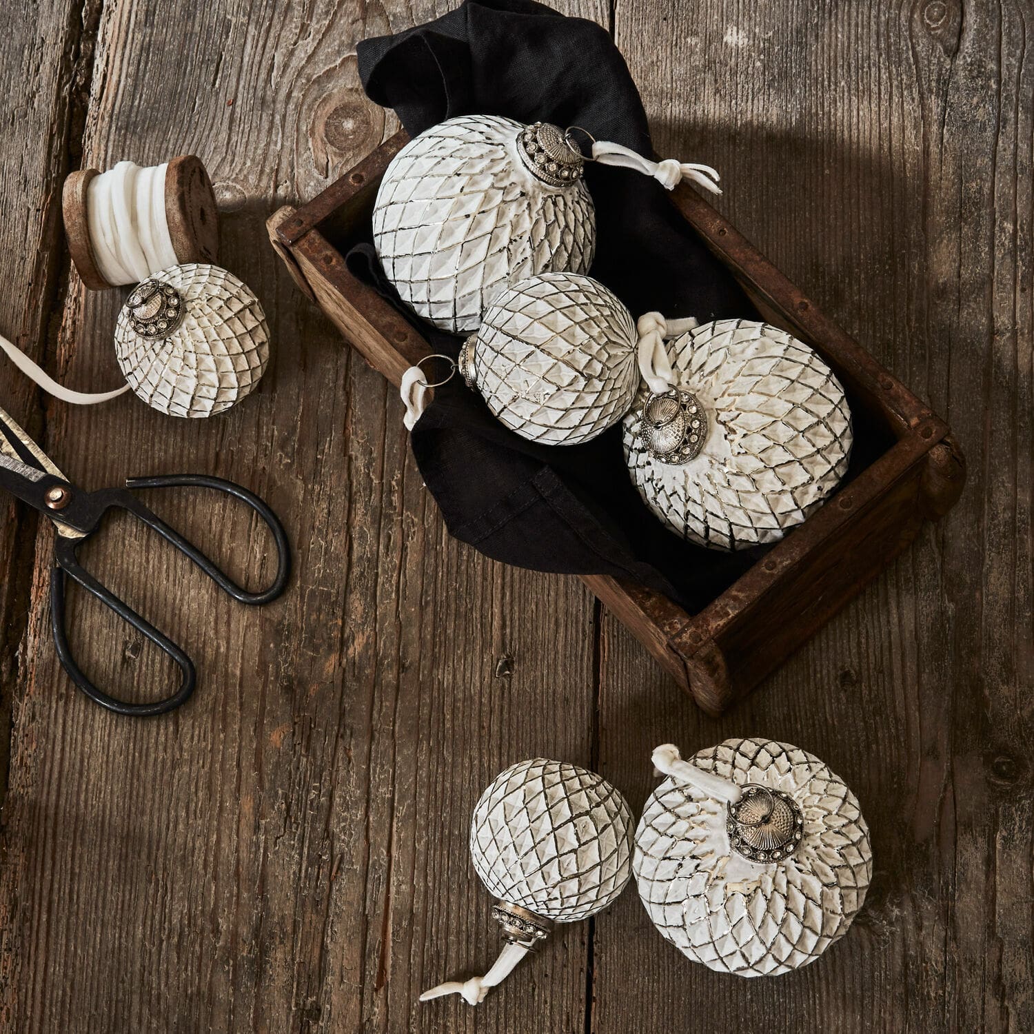 Set di 6 decorazioni natalizie Maélys Decorazioni natalizie bianche in metallo e vetro con motivo a nido d'ape su tavolo di legno con forbici
