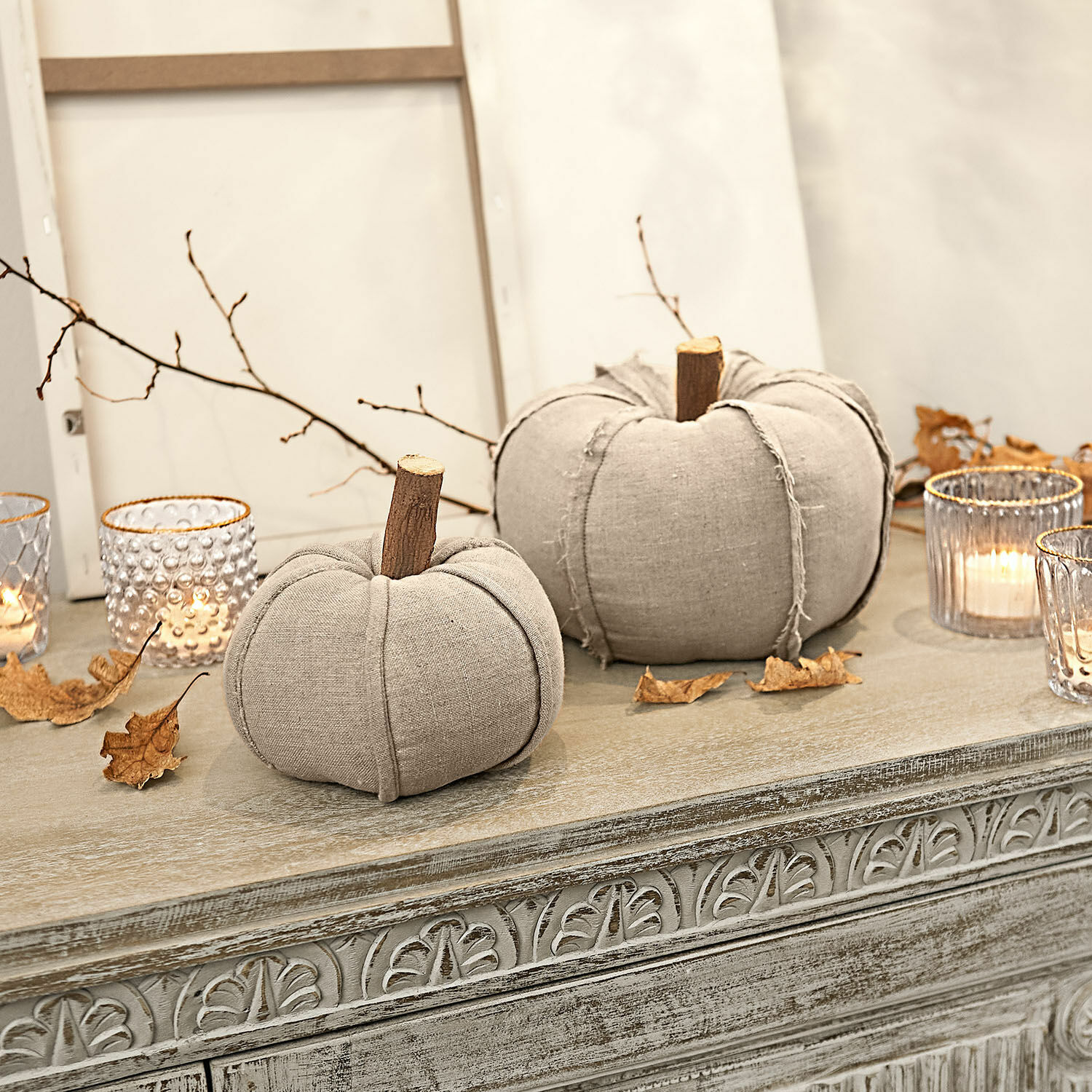 Coppia di zucche Nistalo Zucca decorativa in lino beige con gambi in legno su comò intagliato con lanterne