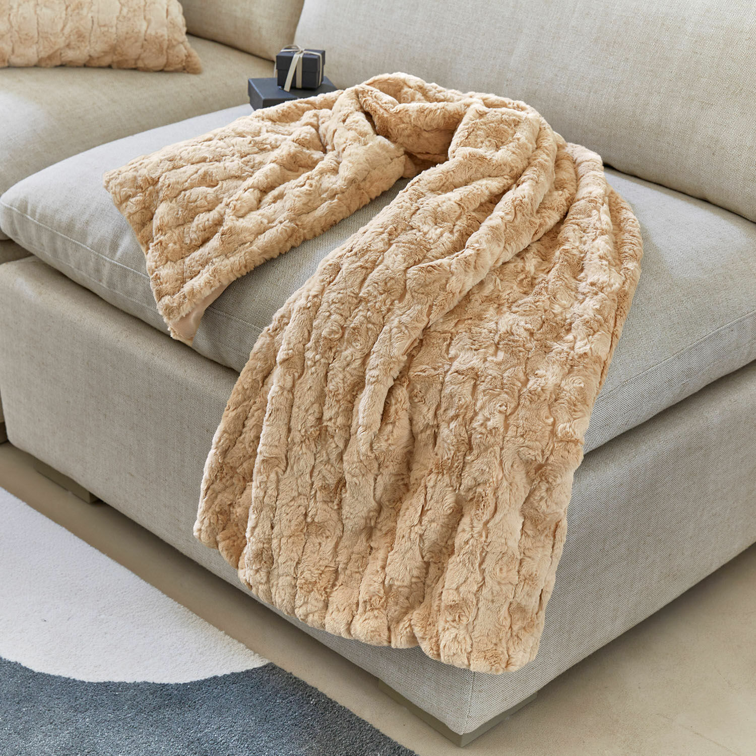 Plaid Dorelice Coperta beige in pelliccia sintetica morbida su divano grigio chiaro per ambienti accoglienti