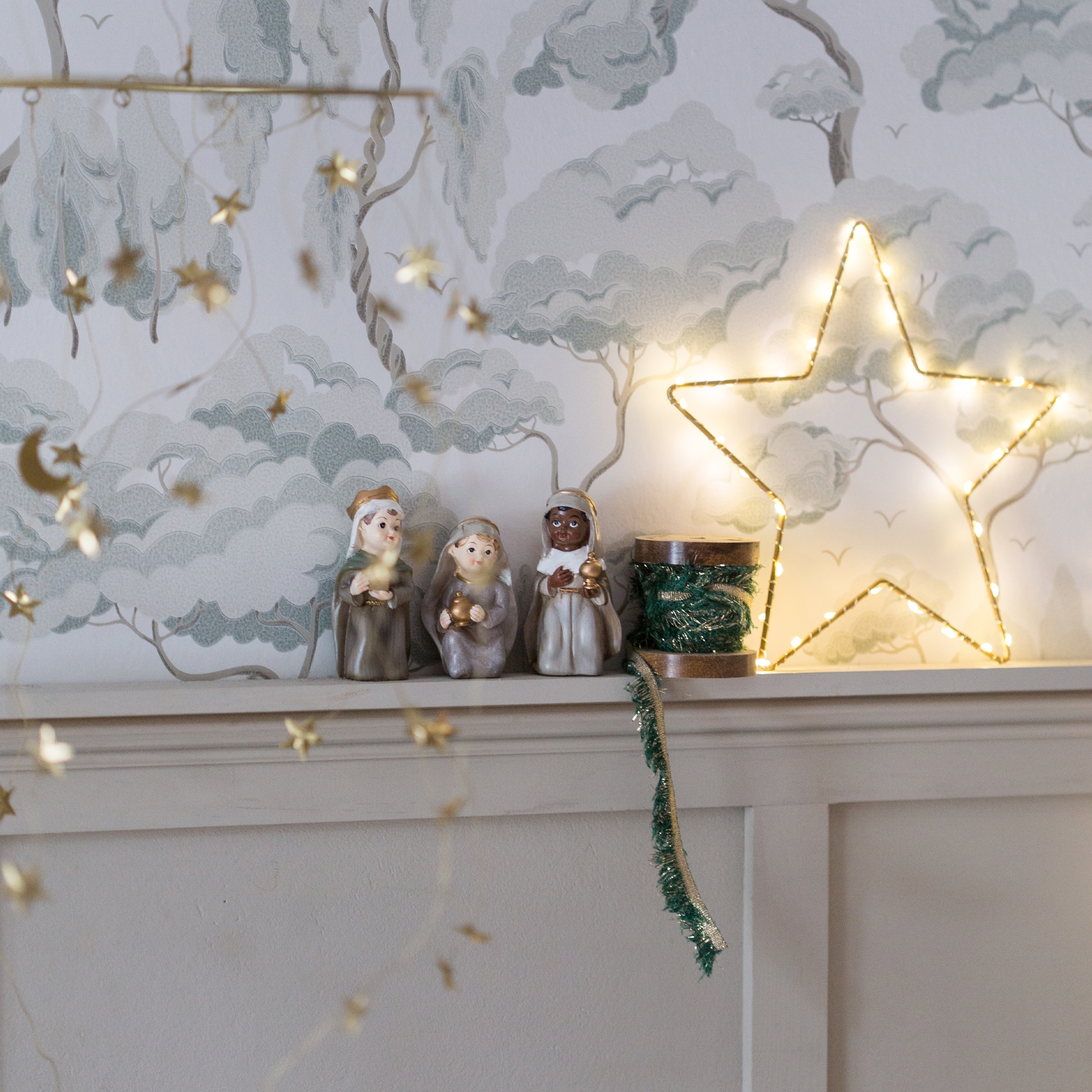 Decorazione natalizia con tre statuine dei Re Magi e stella luminosa su mensola bianca