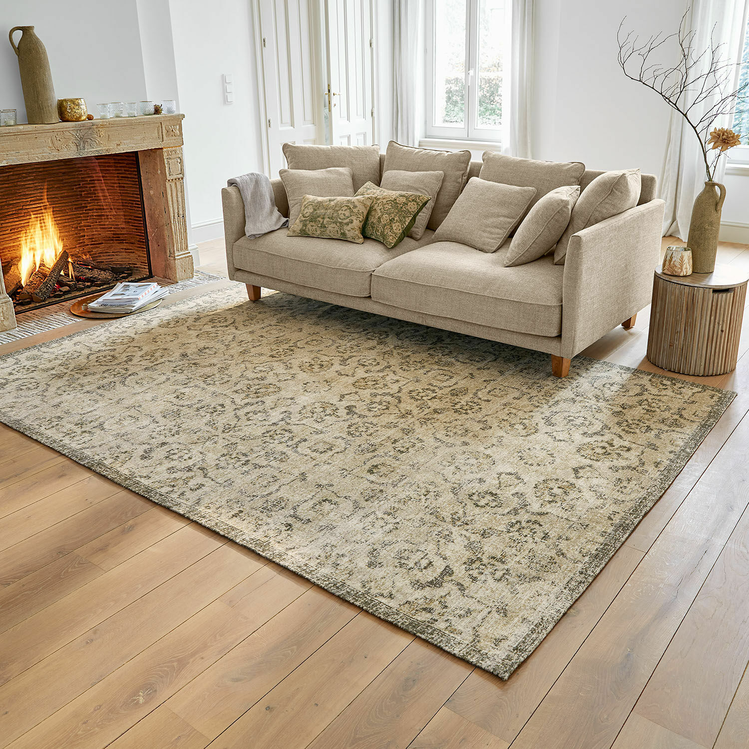 Tappeto Calperino Tappeto beige con motivo delicato su pavimento in legno in soggiorno con divano beige e camino