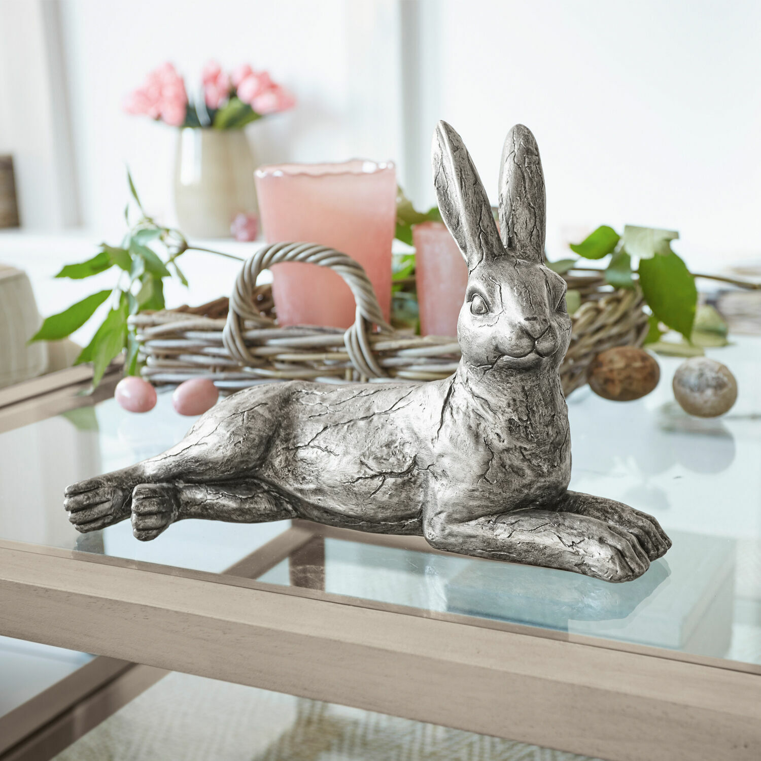Coniglio Fiorentin Coniglio decorativo in metallo argentato su tavolo in vetro con decorazioni primaverili