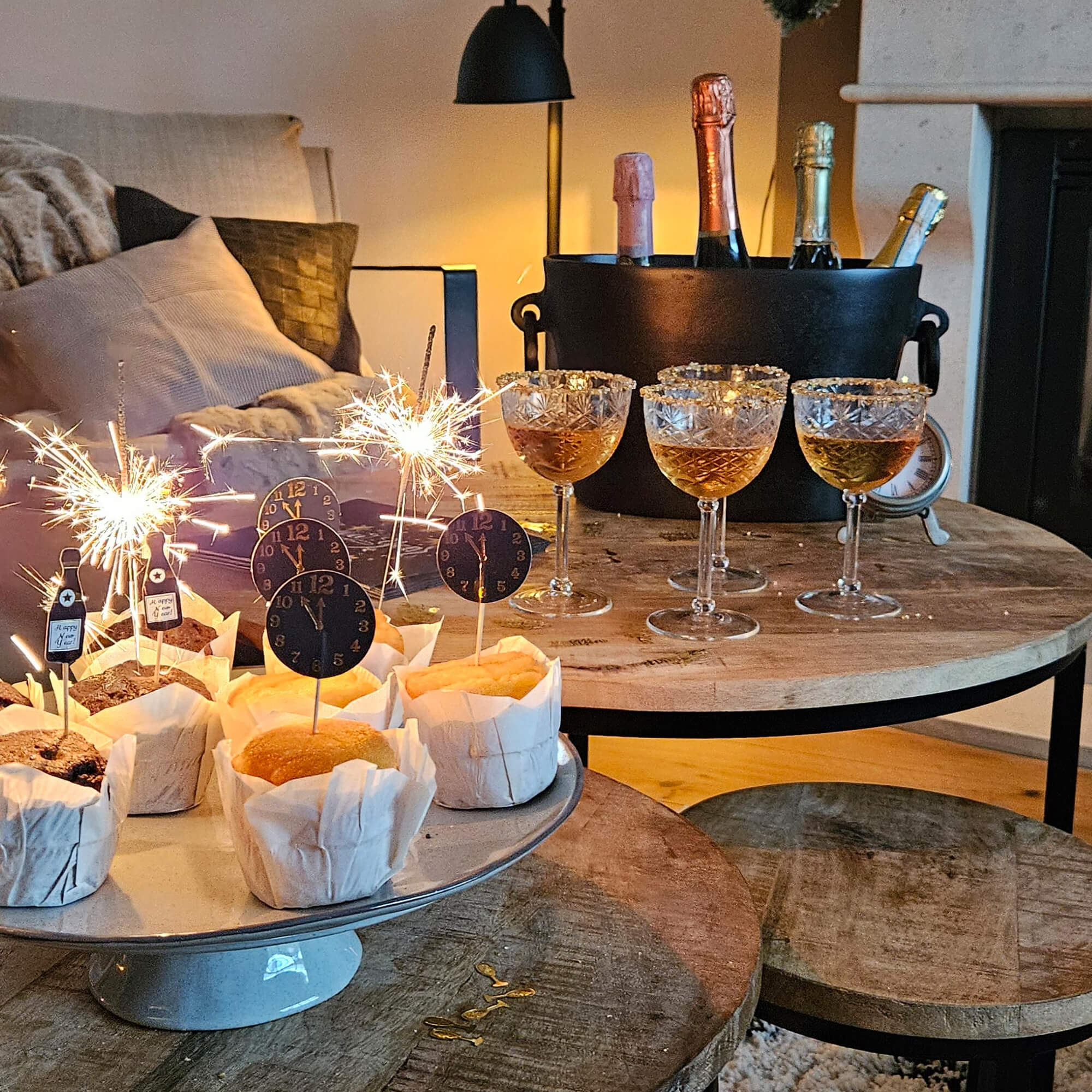 Festa con muffin, bicchieri e bottiglie in secchio su tavolo di legno in ambiente accogliente