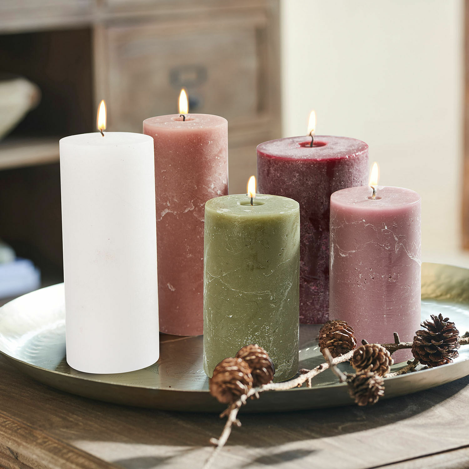 Set di 5 candele Panagra Set di cinque candele di cera colorate su vassoio metallico con decorazione di pigne