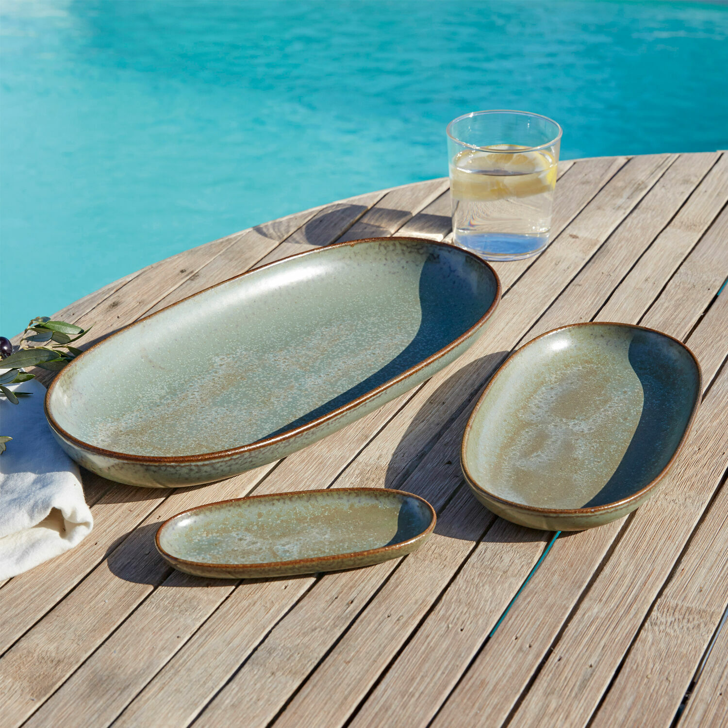 Set di 3 vassoi Biarré Set di tre piatti in ceramica verde su tavolo in legno vicino alla piscina, servizio estivo
