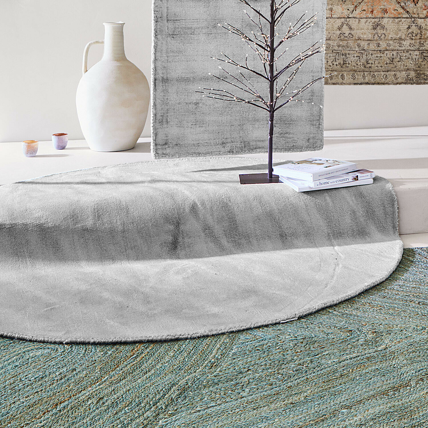 Tappeto Mariselle Tappeto rotondo grigio in materiale morbido con vaso decorativo e libri in un interno moderno
