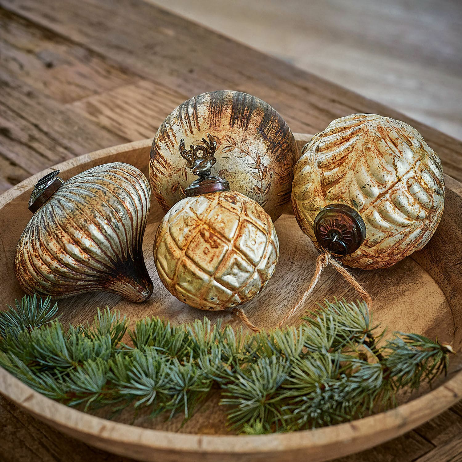 Set di 4 decorazioni natalizie Donia Set di quattro decorazioni natalizie dorate con effetto invecchiato su vassoio di legno con ramo di pino