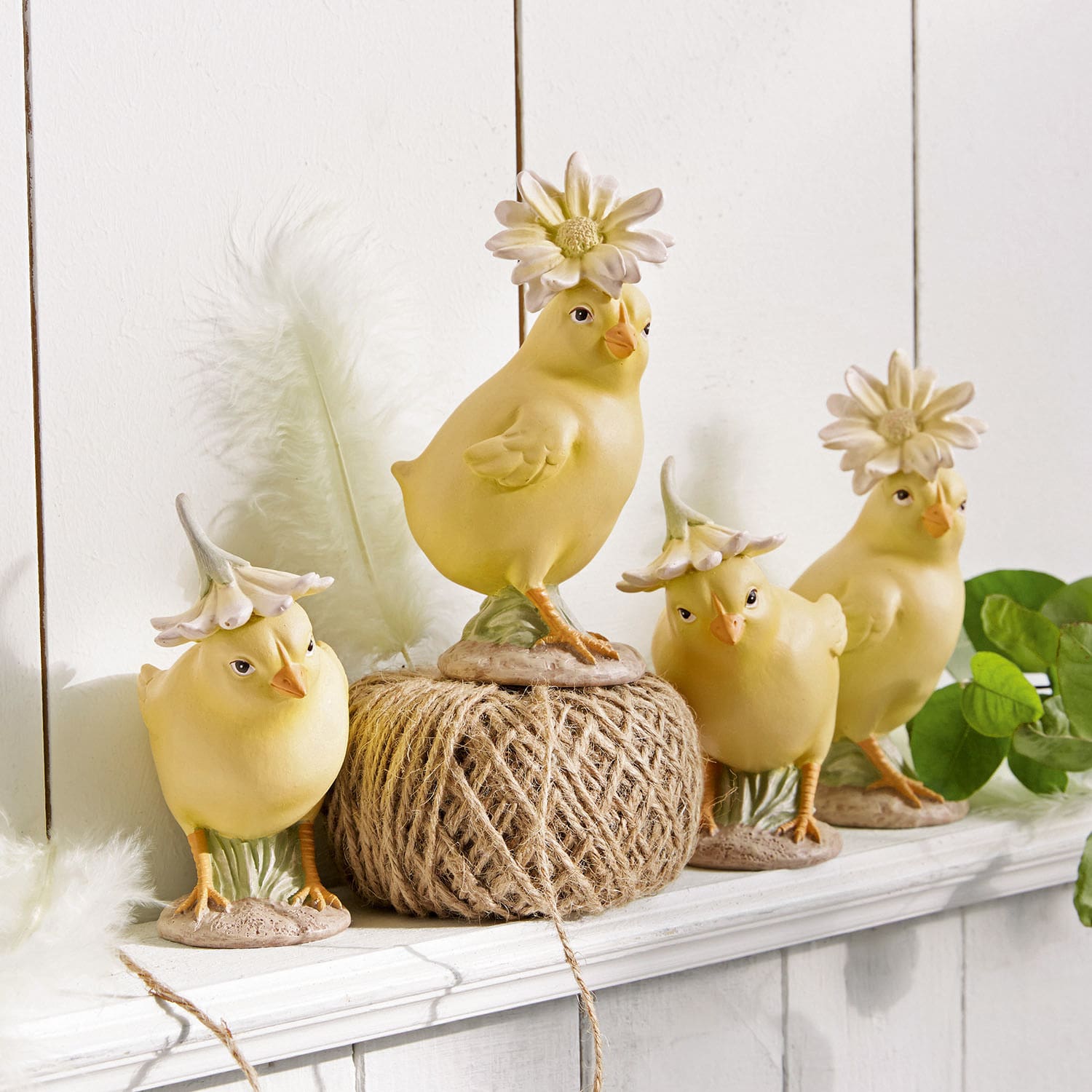 Set di 4 pulcini Garsonne Quattro statuine di pulcini gialli in ceramica con cappelli floreali su una mensola bianca decorativa