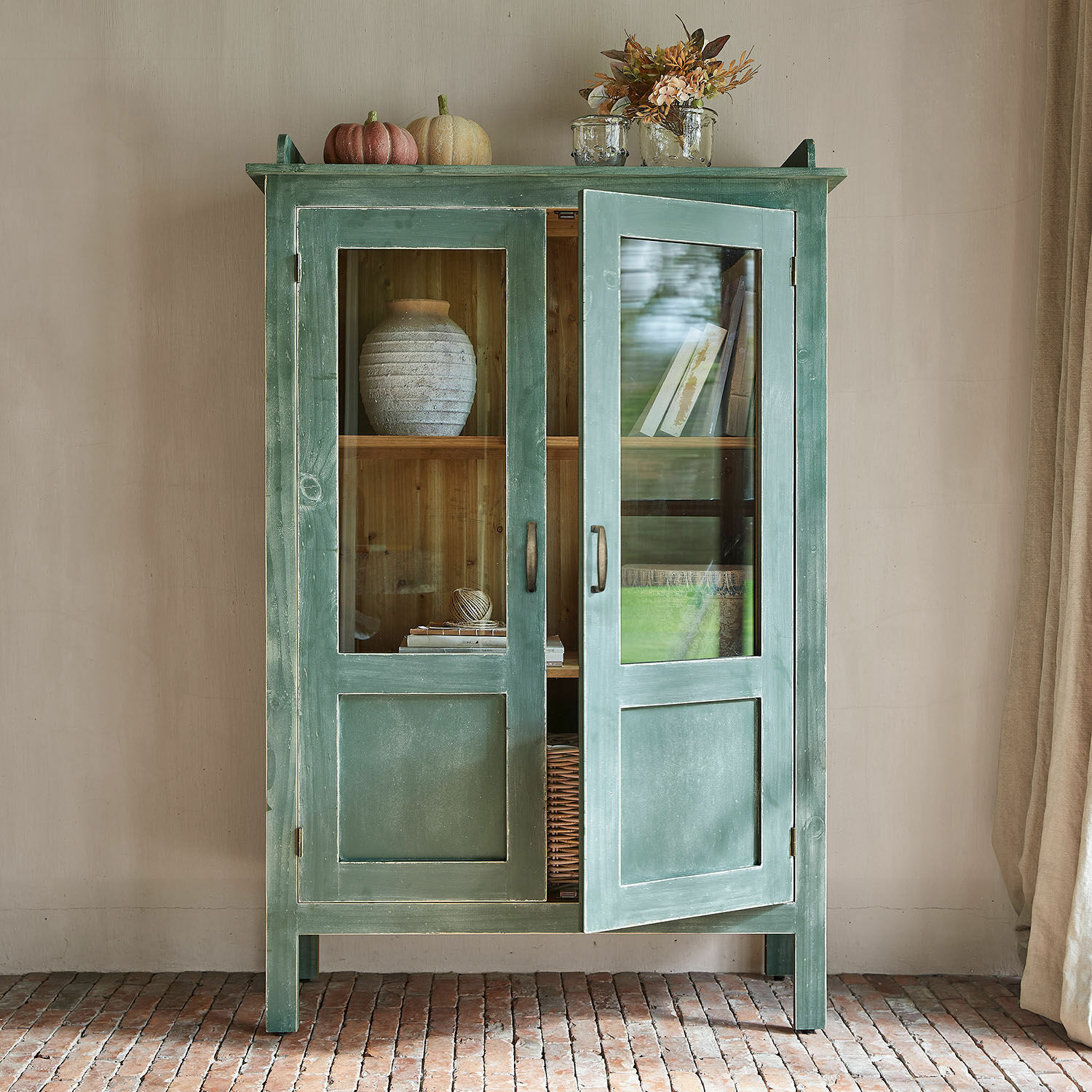 Vetrina Nouvellese Mobile verde in legno con ante in vetro e decorazioni sopra, mobile rustico per soggiorno