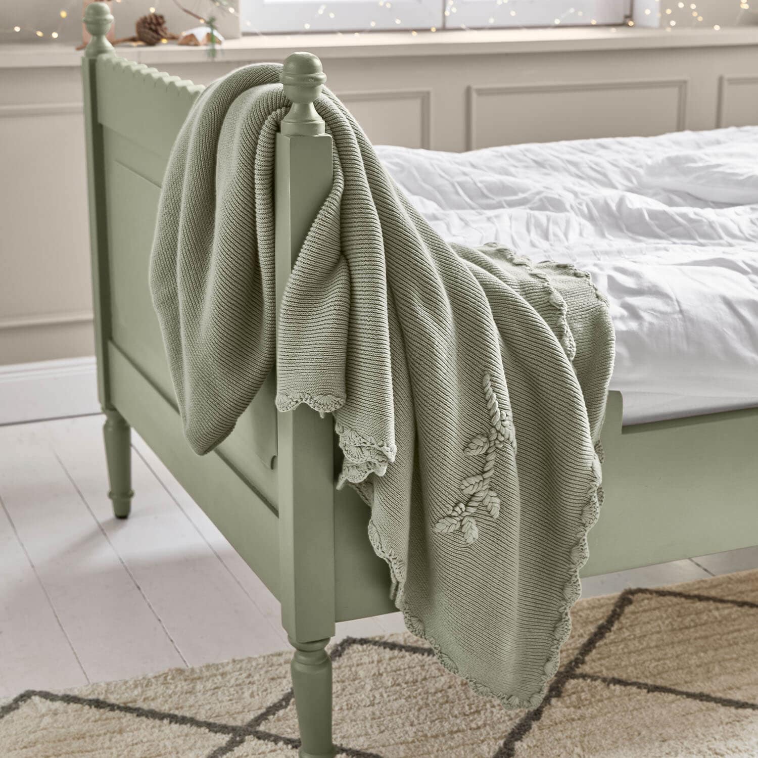 Coperta in cotone verde menta con ricamo decorativo su letto in legno in camera da letto