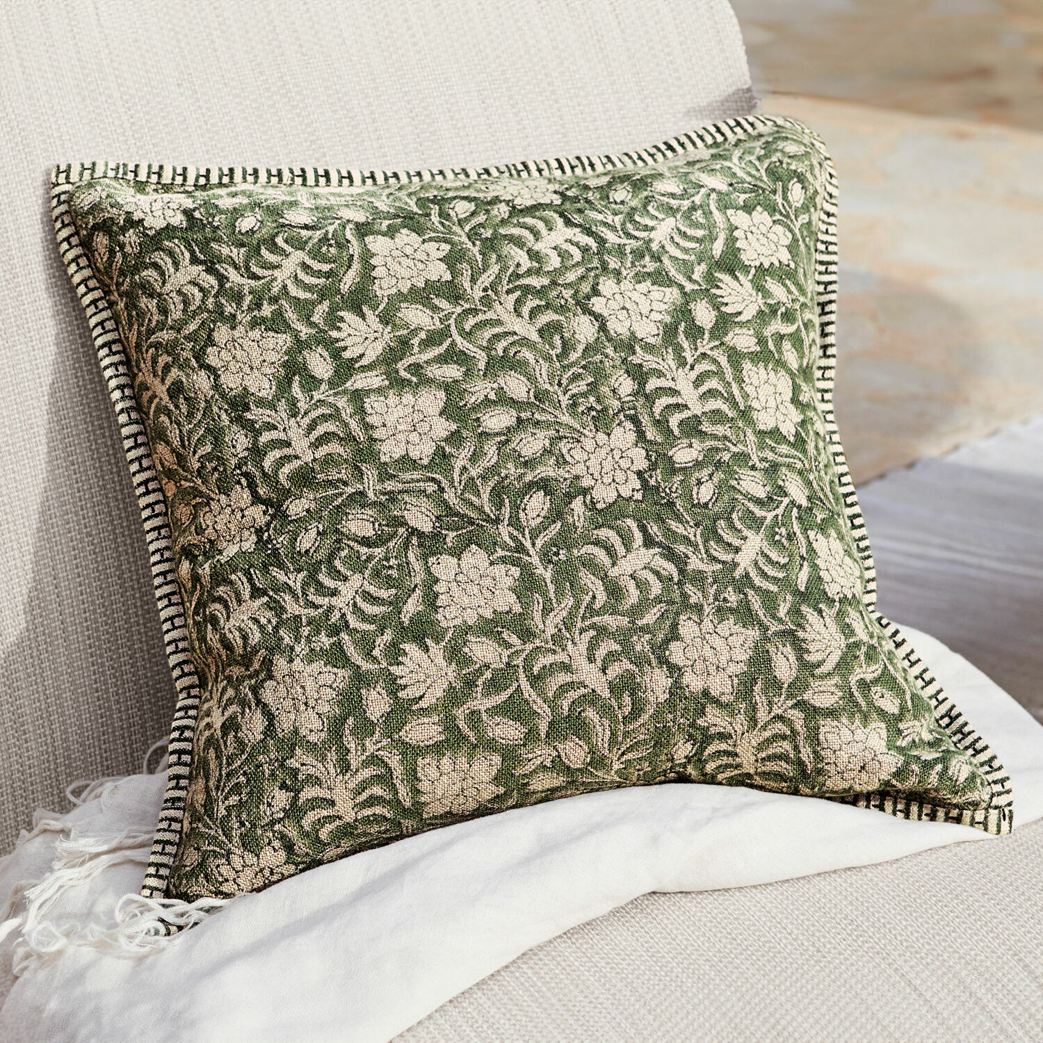 Copricuscino Petitmagny Cuscino decorativo verde in cotone con motivo floreale e bordo bianco e nero su divano chiaro