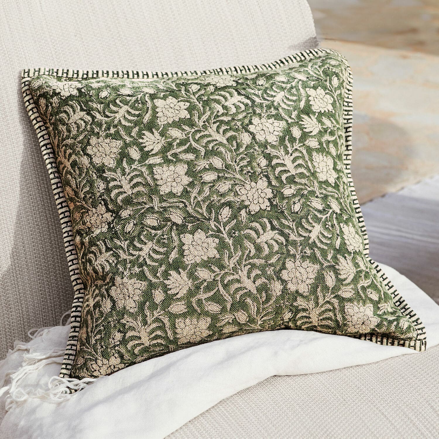 Copricuscino Petitmagny Cuscino decorativo verde in cotone con motivo floreale e bordo bianco e nero su divano chiaro