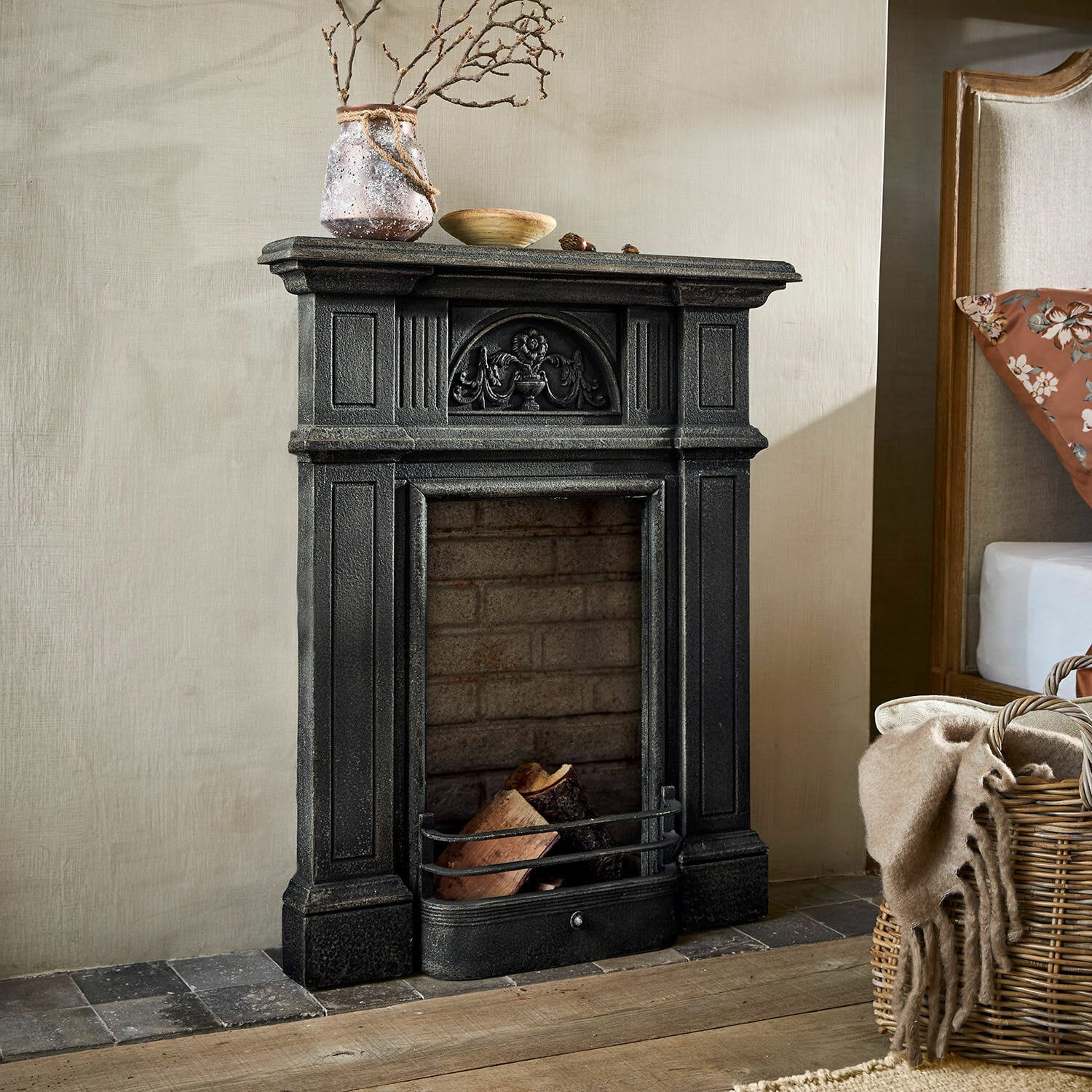 Consolle caminetto Corvelle Camino decorativo nero in ghisa con legna e ornamenti in interno rustico