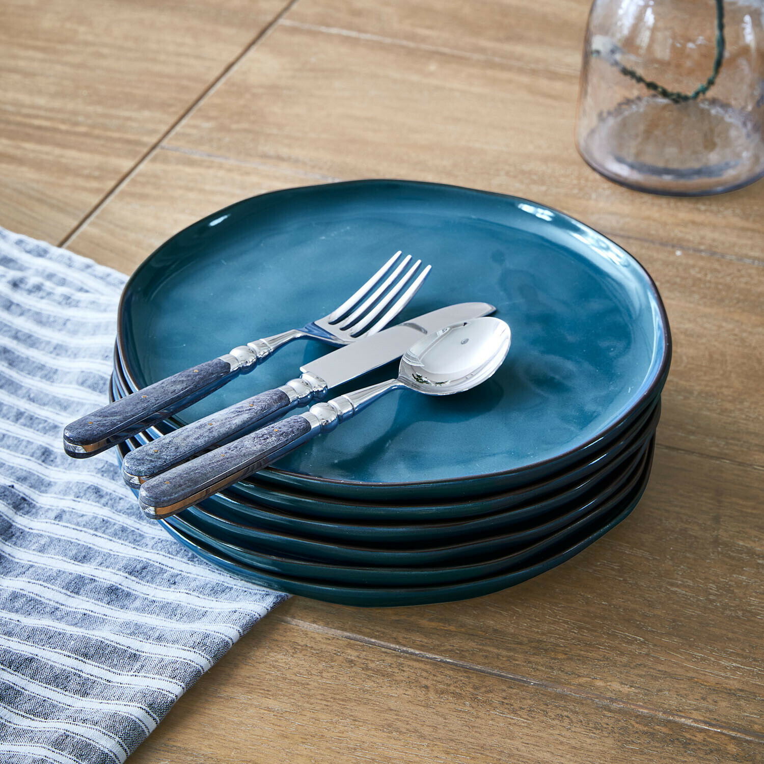 Set di 6 piatti Biarré Set di piatti in ceramica blu con posate in metallo e manici in legno su tavolo in legno