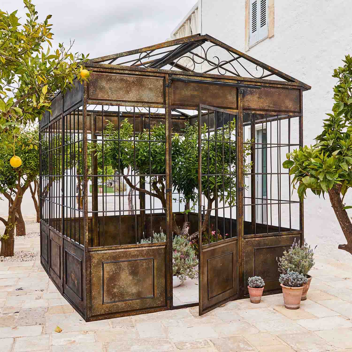 Gazebo in metallo vintage con piante e alberi di agrumi su terrazza in pietra
