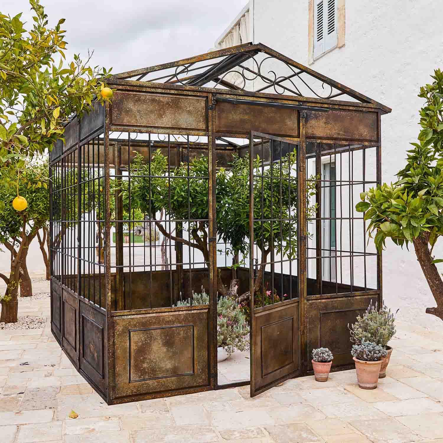 Gazebo in metallo vintage con piante e alberi di agrumi su terrazza in pietra