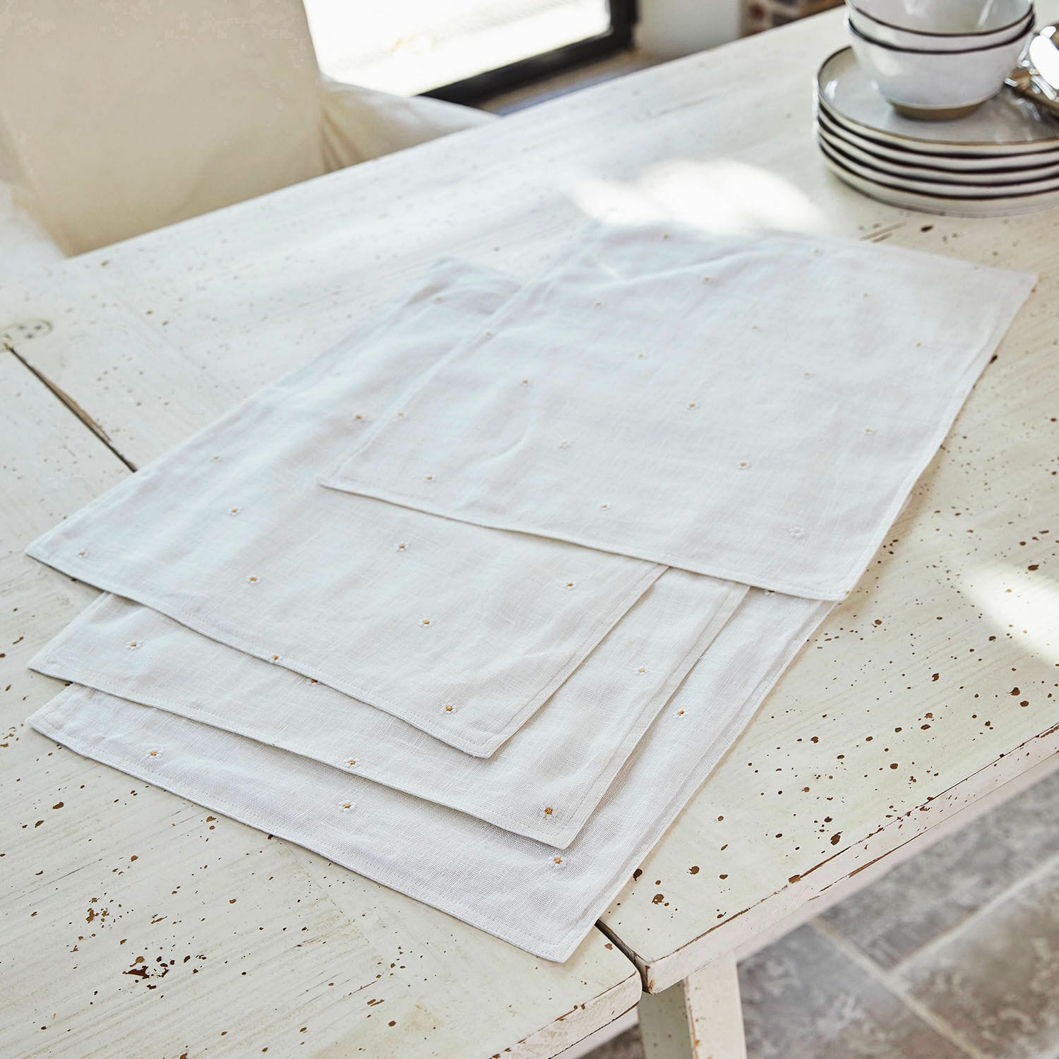 Set di 4 tovagliette Lentilly Tovaglioli in lino bianco con delicato ricamo su tavolo rustico, decorazione elegante per tavola