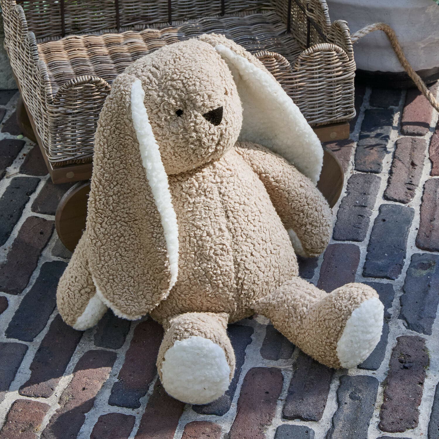 Peluche Fluffernap Coniglio di peluche beige morbido con orecchie e zampe bianche su pavimento in mattoni