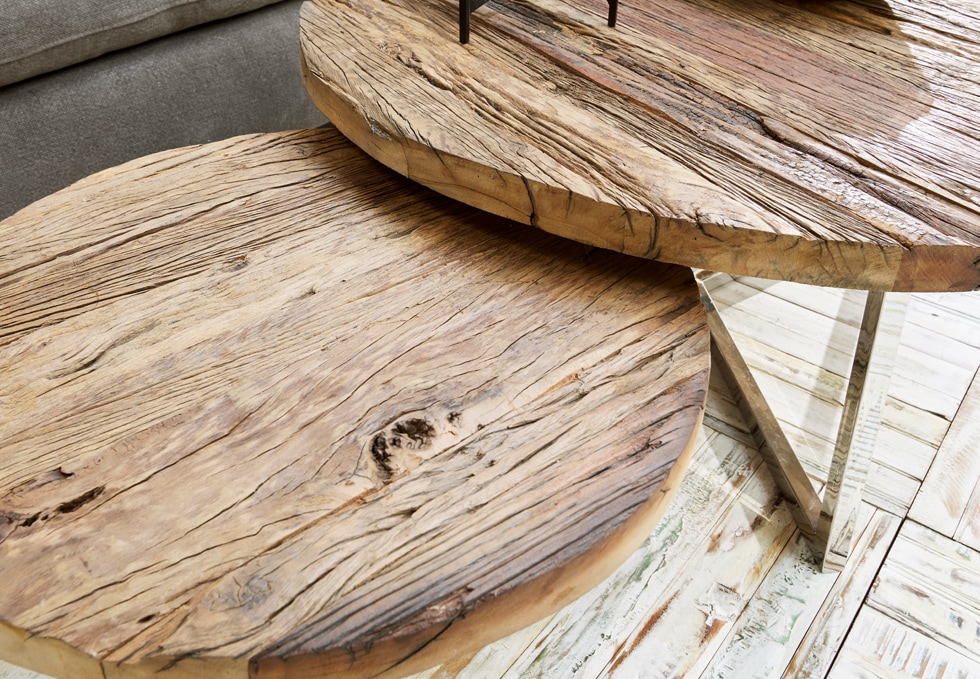 Due tavoli rotondi in legno naturale con venature visibili e gambe in metallo in stile industriale