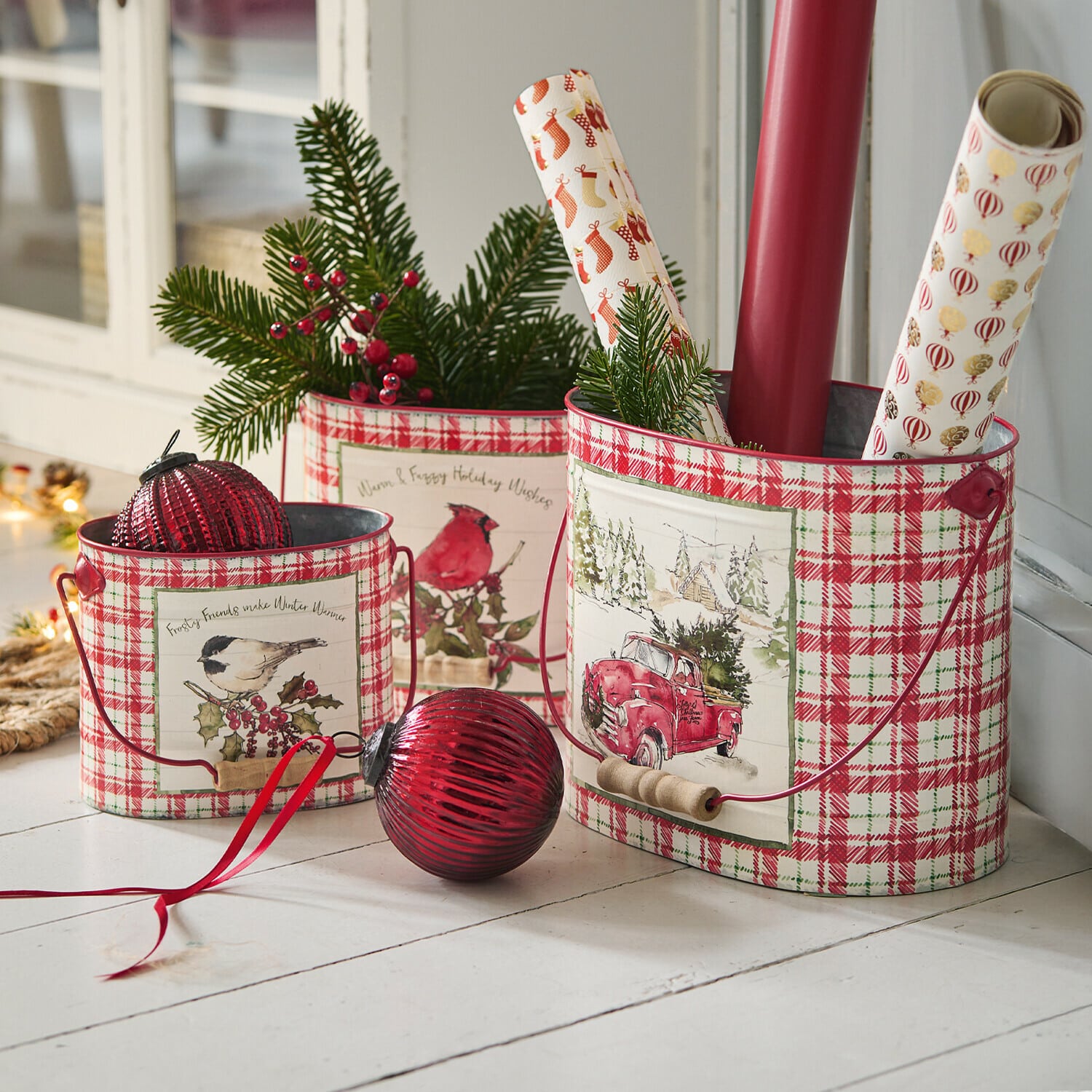 Set di 3 portavasi Fuzzy Set di tre contenitori in metallo a quadri rossi e bianchi con motivi natalizi e rami verdi decorativi