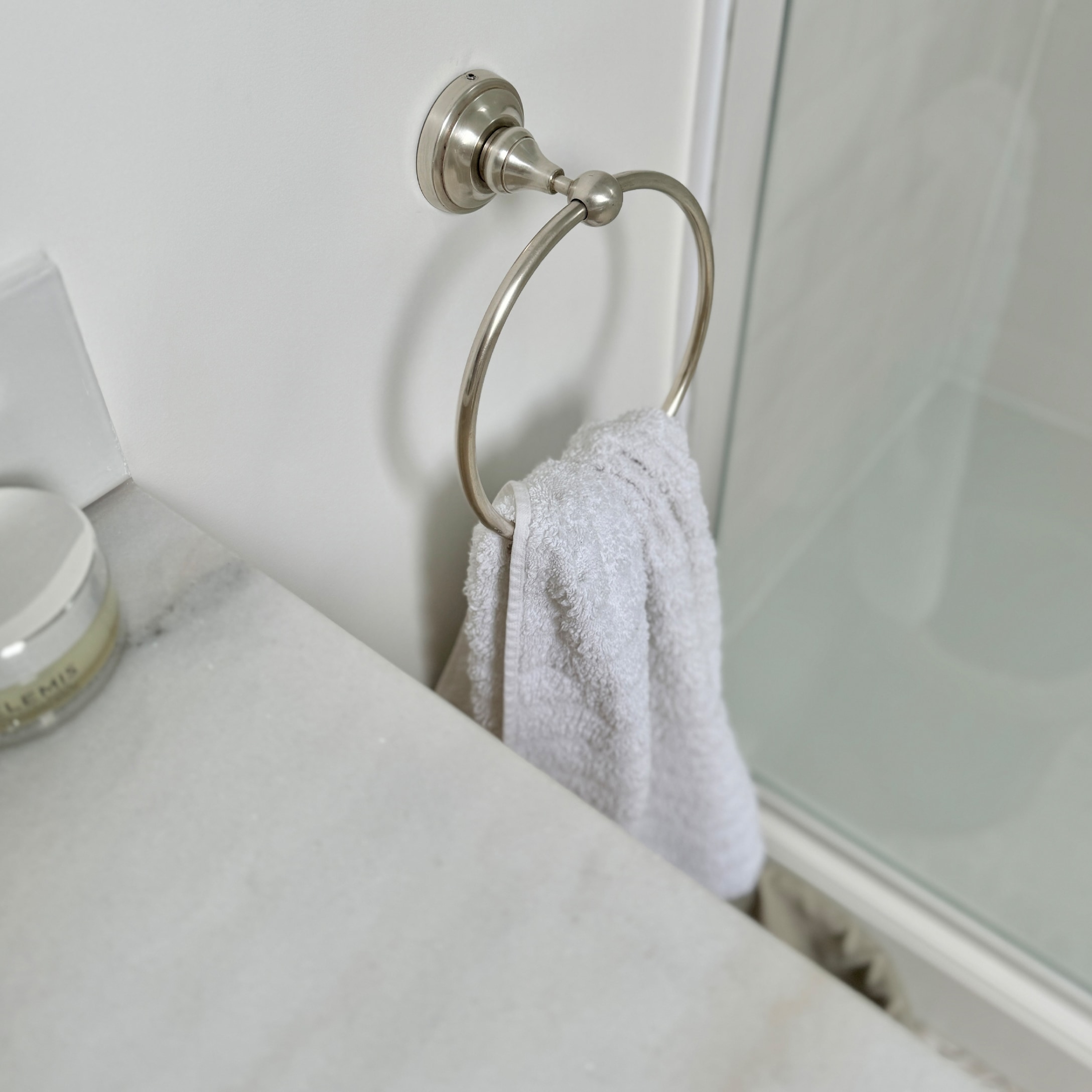 Porta asciugamani in metallo con asciugamano bianco e piano in marmo in bagno