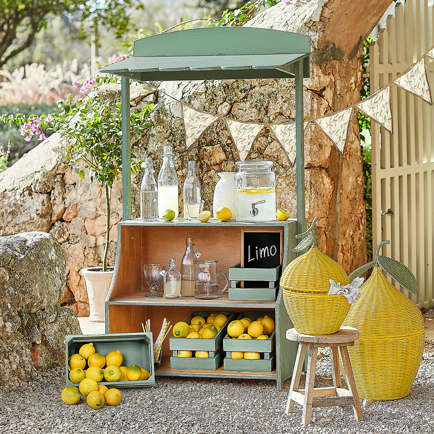 Chiosco di limonate Éclairon Espositore in legno verde con limoni e bottiglie di vetro per limonata in giardino