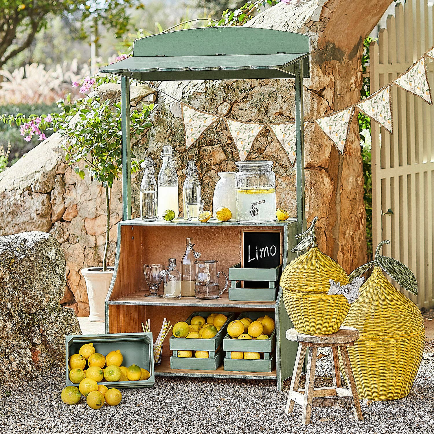 Chiosco di limonate Éclairon Espositore in legno verde con limoni e bottiglie di vetro per limonata in giardino