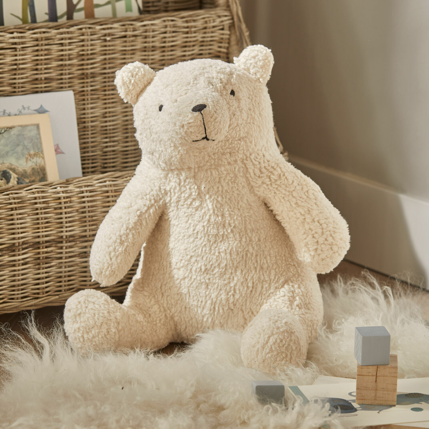 Animale di stoffa Hugo Orso di peluche morbido color crema su tappeto in materiali naturali, decorazione per cameretta