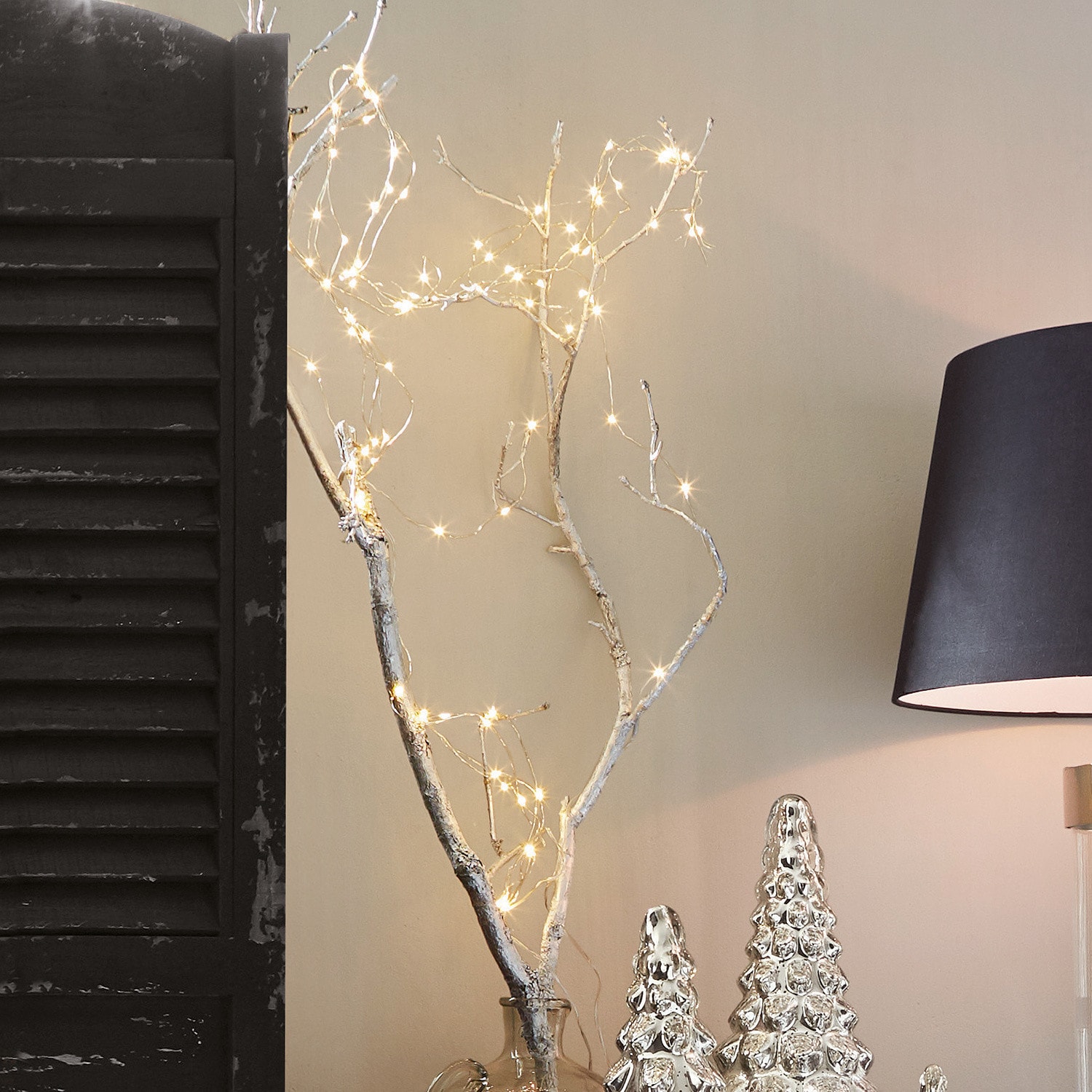 Catena luminosa Loperhet Ramo decorativo con luci LED in vaso di vetro accanto a decorazioni natalizie argento e lampada nera