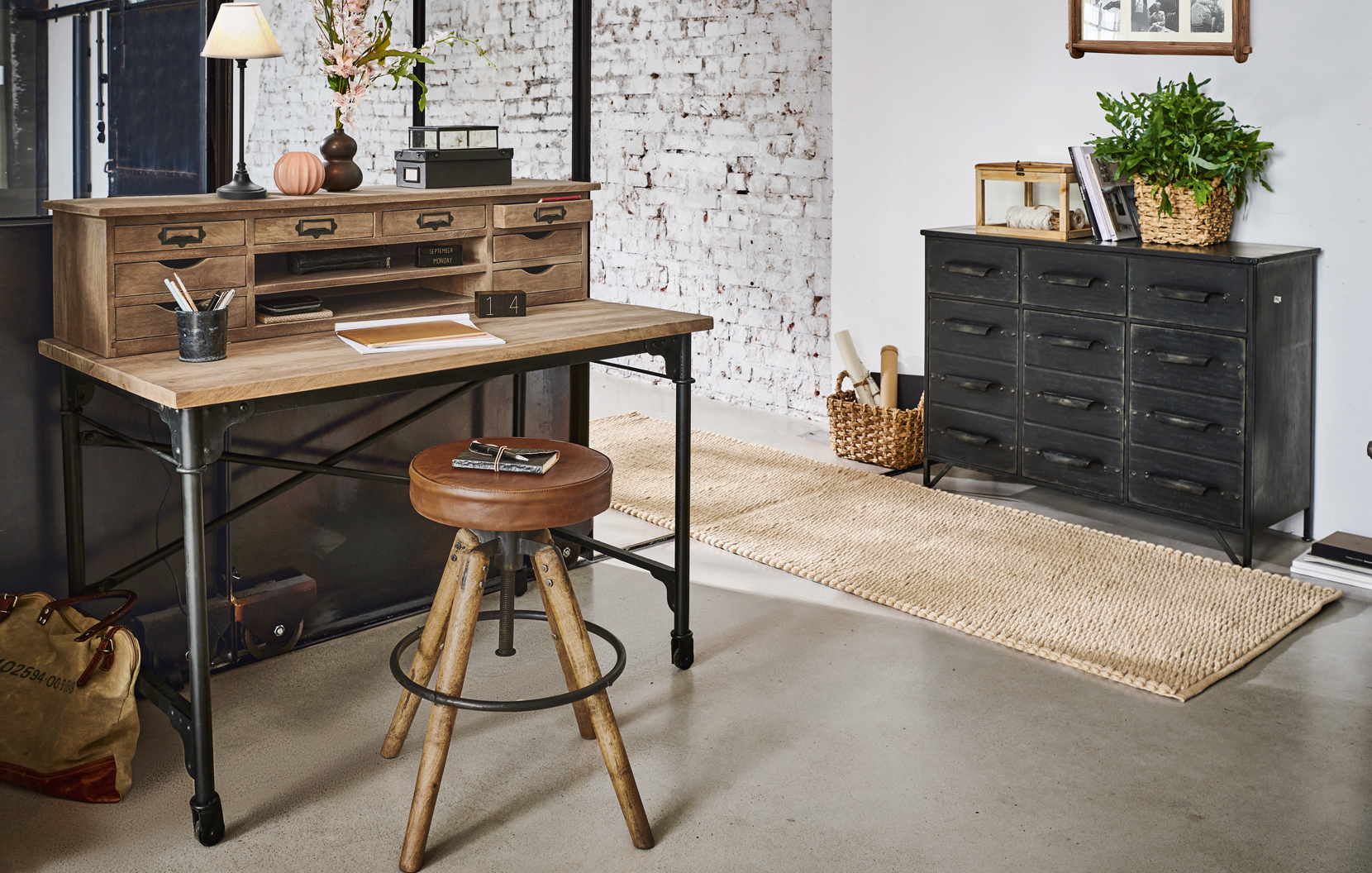 Scrivania industriale in legno e metallo con molti cassetti e sgabello in pelle vintage in interno moderno