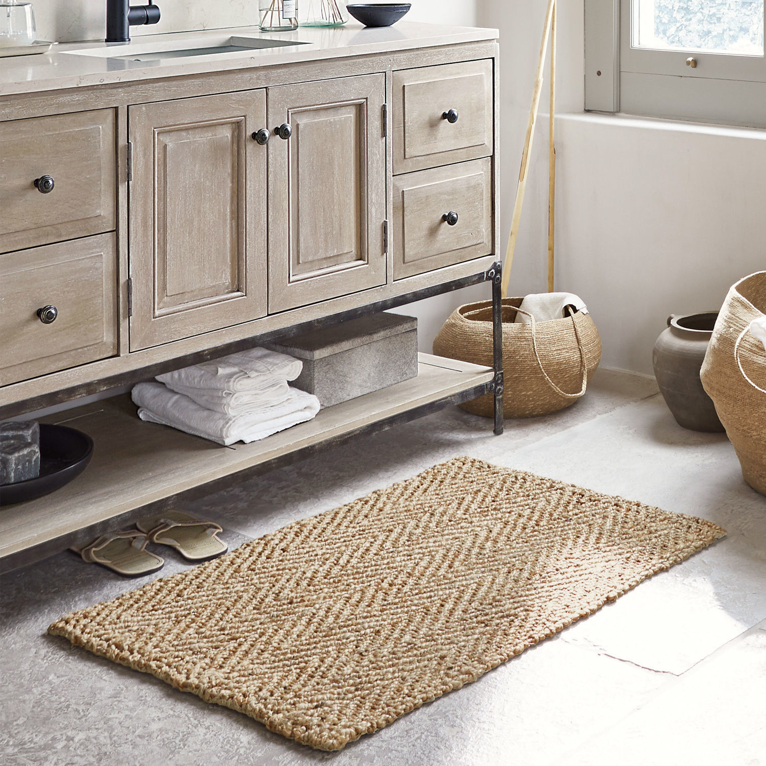 Scendibagno Daoukro Tappeto beige in juta con motivo a spina di pesce in bagno con mobile in legno e cesti