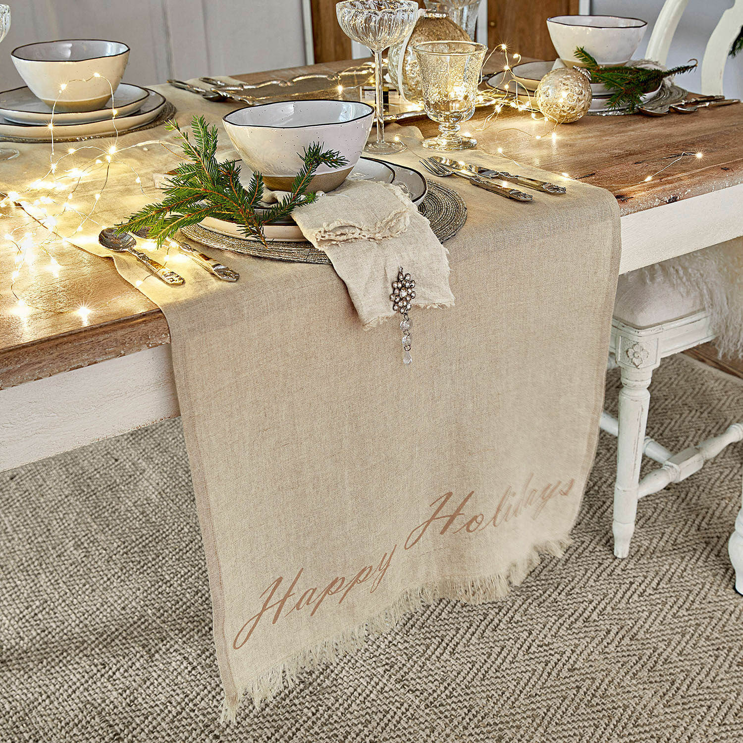 Runner Emilia Runner da tavola in lino beige su tavolo in legno con decorazioni natalizie e stoviglie