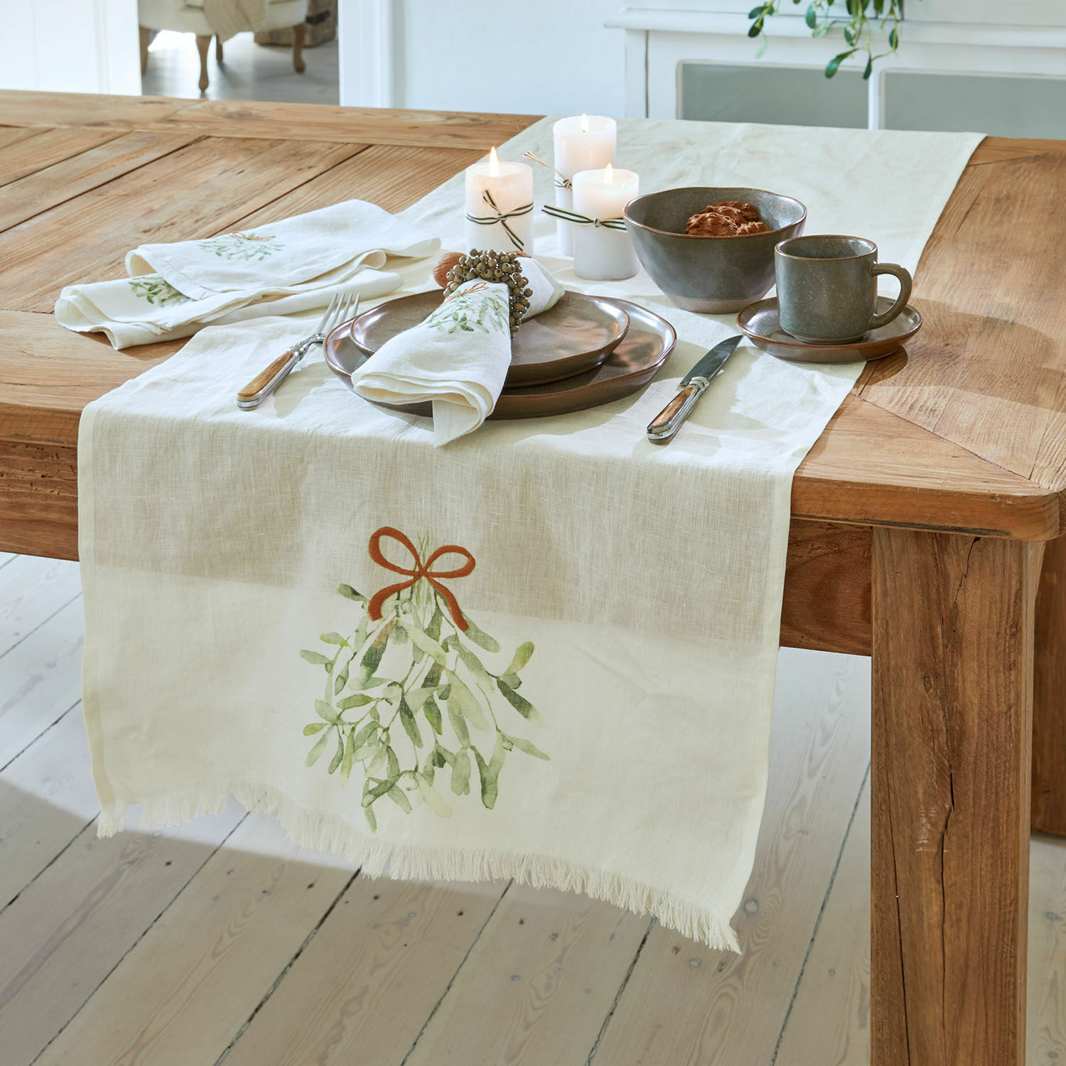 Runner Mistletoe Runner da tavola in lino con motivo di vischio su tavolo in legno con stoviglie rustiche