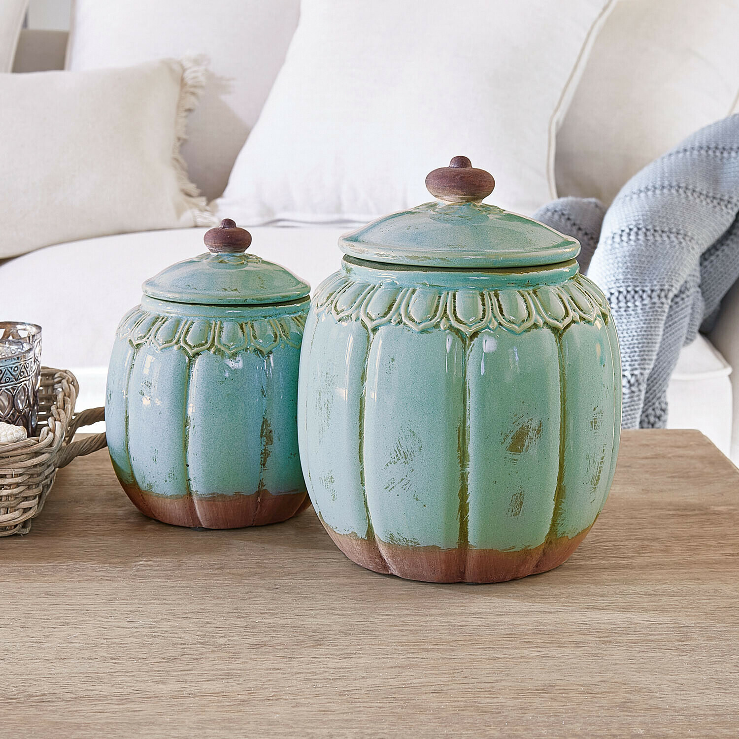 Set di due barattoli in ceramica verde con dettagli marroni su tavolo in legno