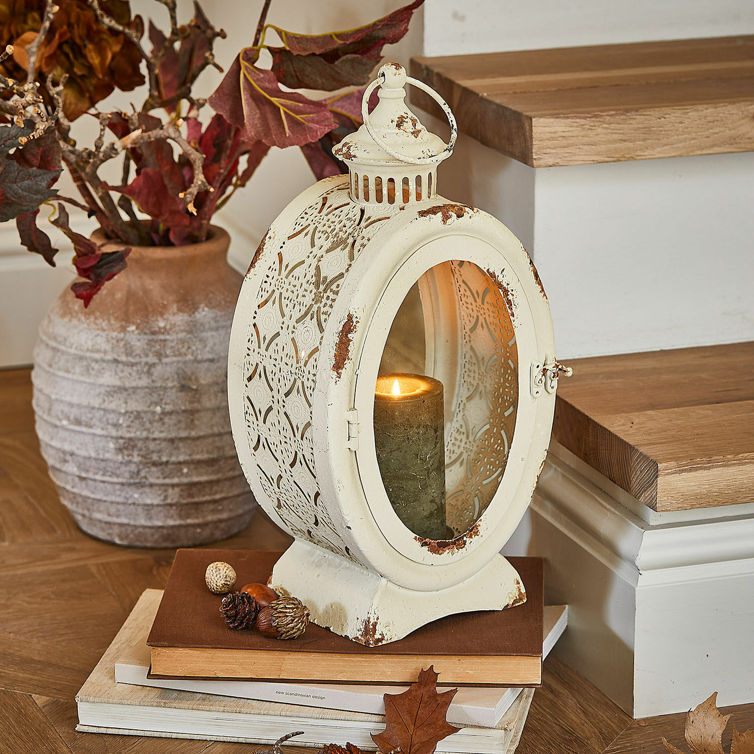 Lanterna Sublimelle Lanterna vintage in metallo color crema con candela accesa e decorazioni autunnali su libri