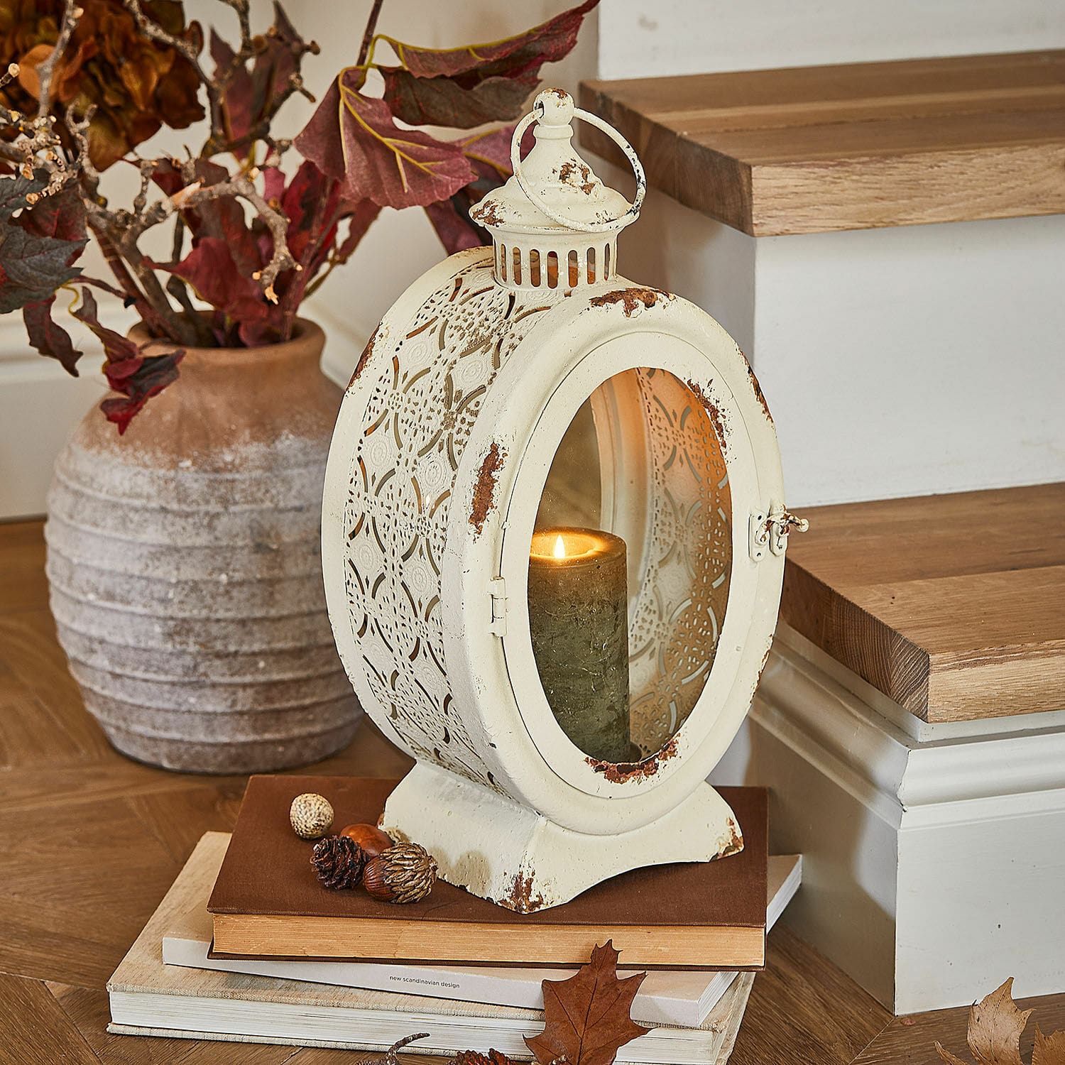 Lanterna Sublimelle Lanterna vintage in metallo color crema con candela accesa e decorazioni autunnali su libri