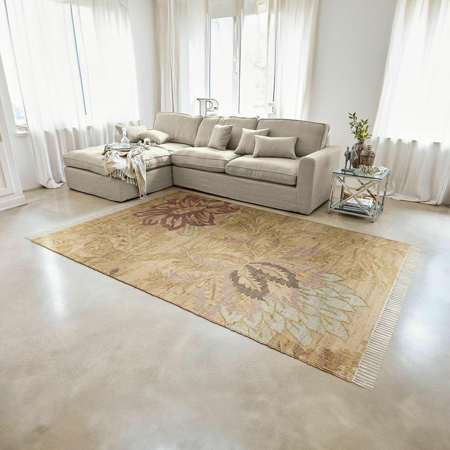 Tappeto Willeque Tappeto beige con motivo floreale su pavimento chiaro in soggiorno moderno con divano grigio