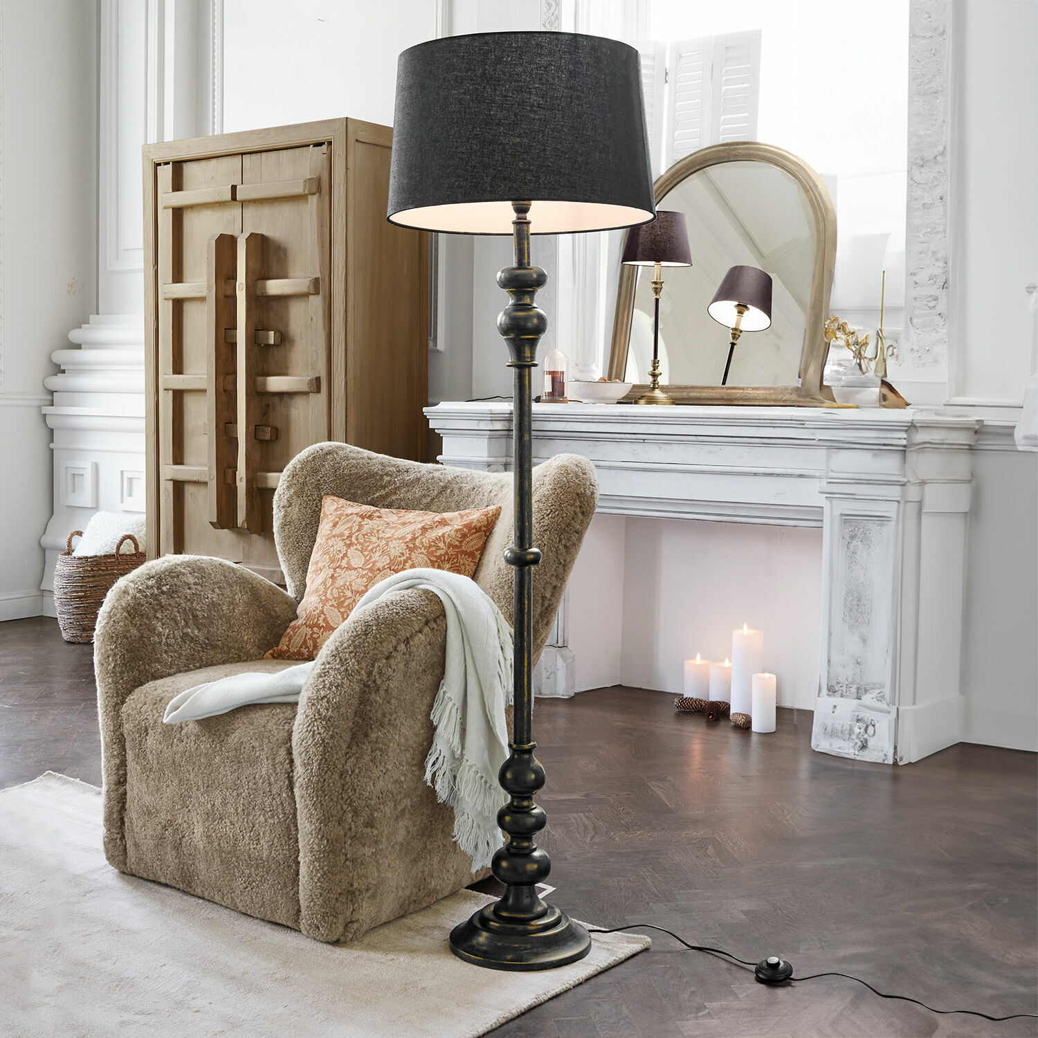Lampada a stelo Reville Lampada da terra nera con paralume in soggiorno classico con poltrona beige e camino bianco