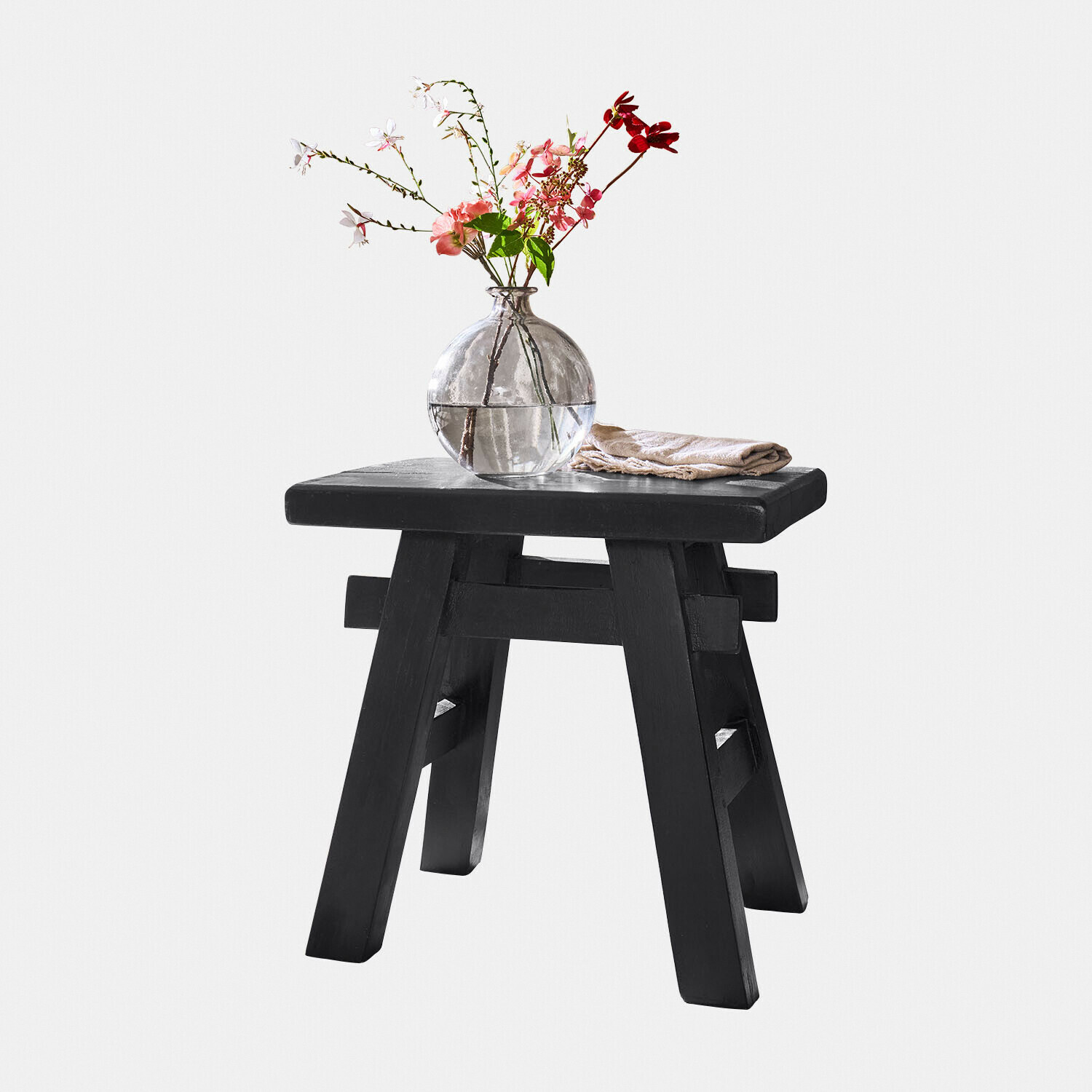 Sgabello in legno nero con vaso di vetro rotondo e fiori, decorazione d'interni elegante