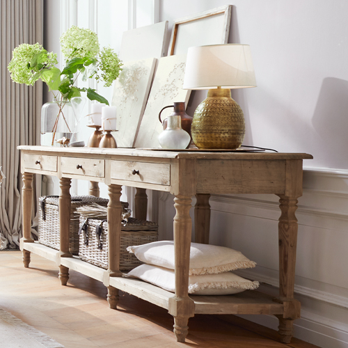 Consolle in legno naturale con decorazioni e lampada su pavimento chiaro in ambiente elegante
