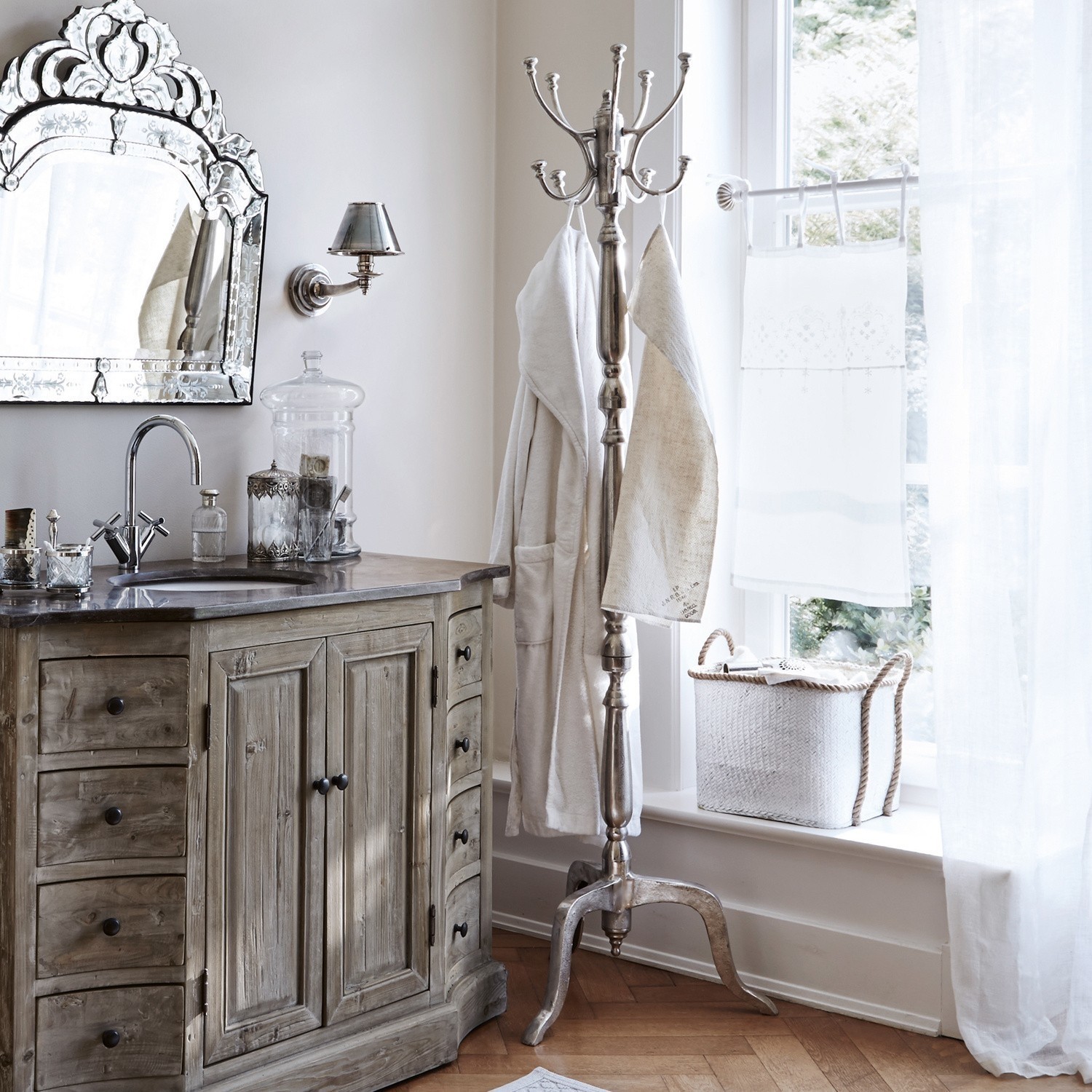 Bagno elegante con mobile in legno, appendiabiti in metallo e specchio decorativo in tonalità chiare