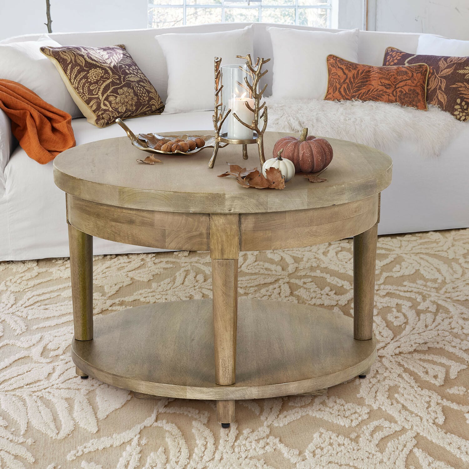 Tavolino da salotto Talinar Tavolino rotondo in legno colore naturale con decorazioni di candela e zucche su tappeto beige