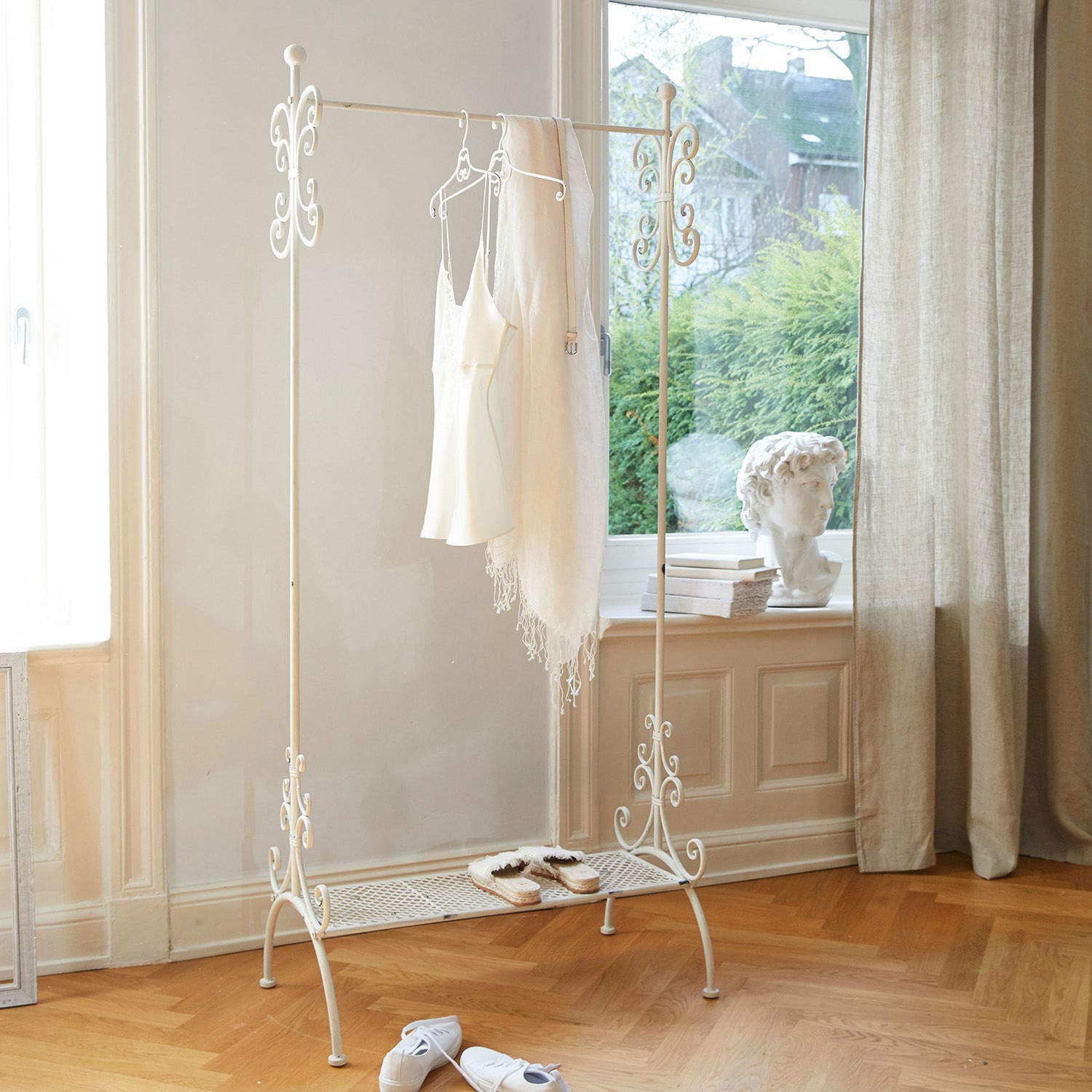 Appendiabiti Épinay Appendiabiti in metallo bianco con dettagli decorativi e ripiano per scarpe in stanza luminosa