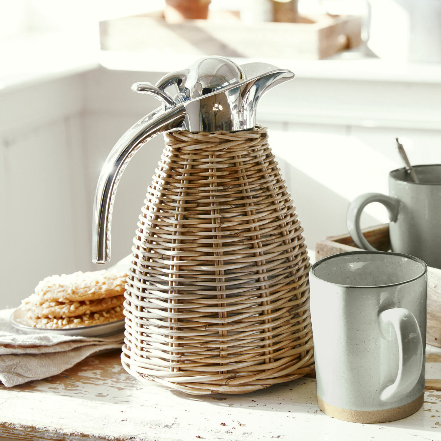 Thermos Senta Thermos in rattan con tappo e manico in metallo su tavolo rustico in cucina