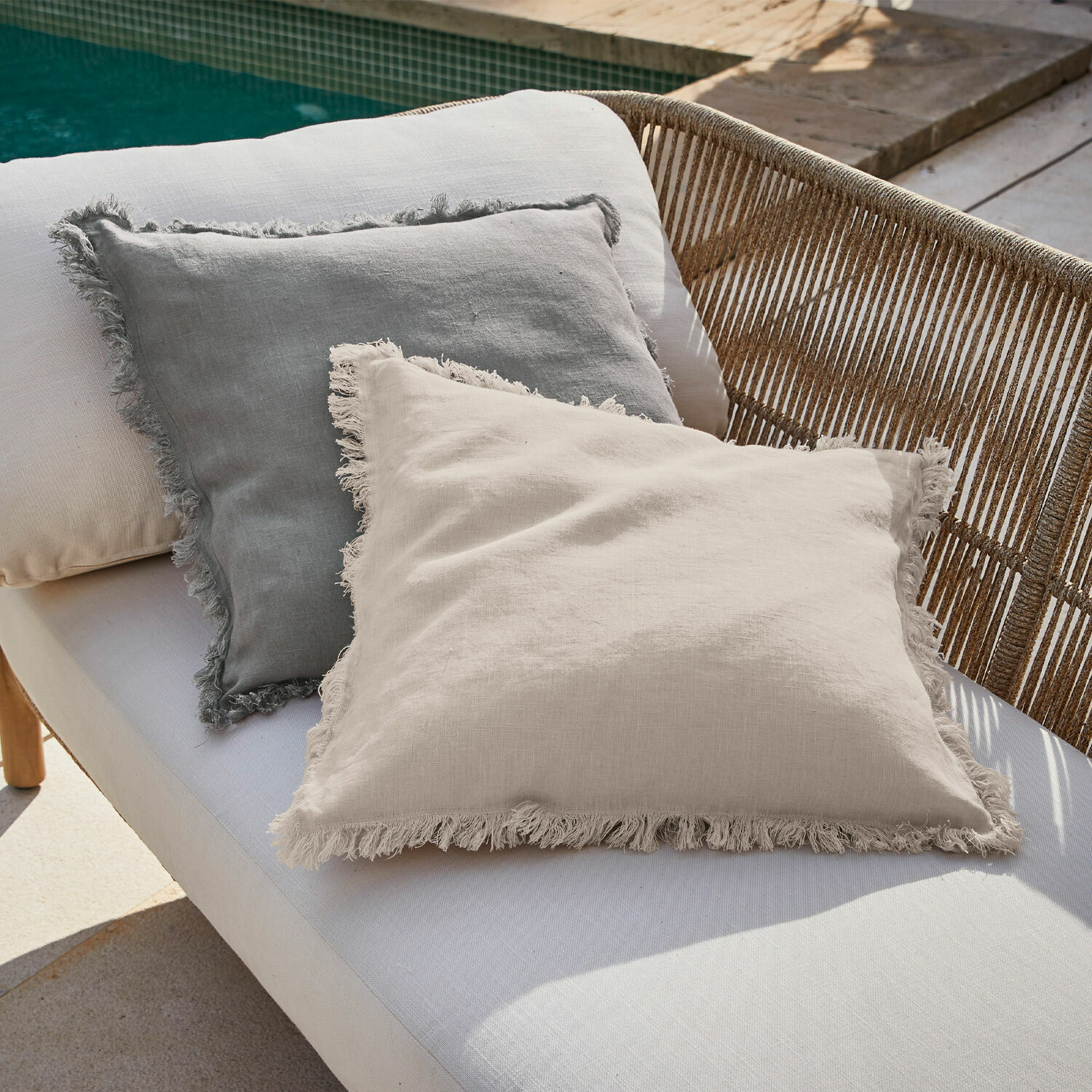 Coppia di copricuscini Quebo Cuscini decorativi in lino beige e grigio con frange su divano da est vicino alla piscina
