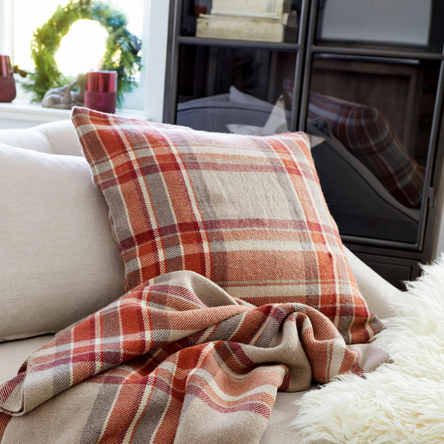 Copricuscino Tartan Cuscino e coperta a quadri rossi e beige su divano chiaro in soggiorno accogliente
