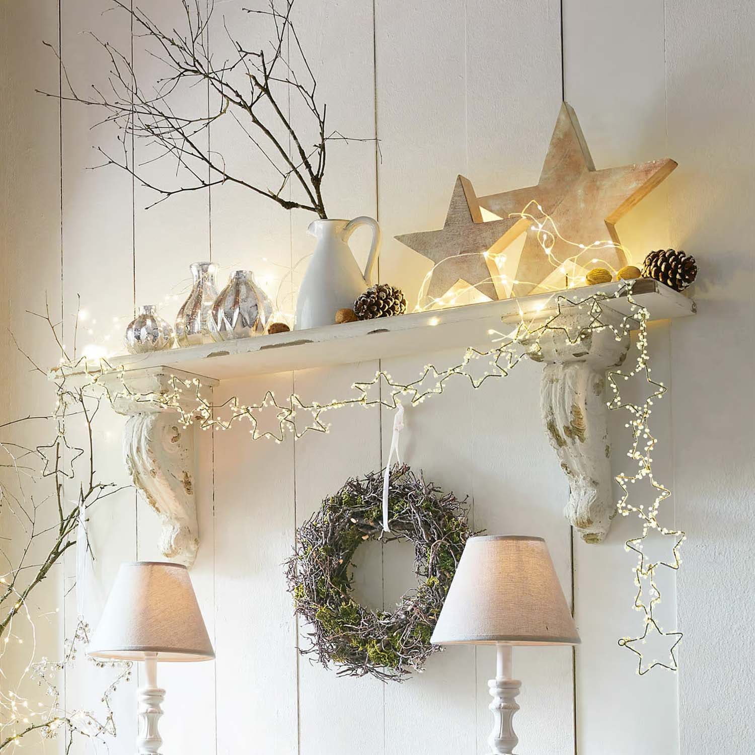 Mensola decorativa bianca in legno con luci a forma di stella, corona e lampade da tavolo in stile rustico