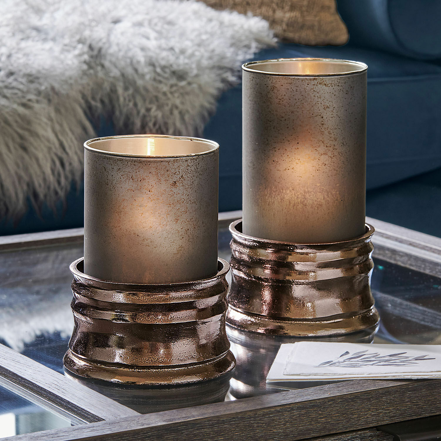 Coppia di portalumini Eirun Due portacandele decorativi in vetro e metallo color rame su tavolino in vetro in soggiorno