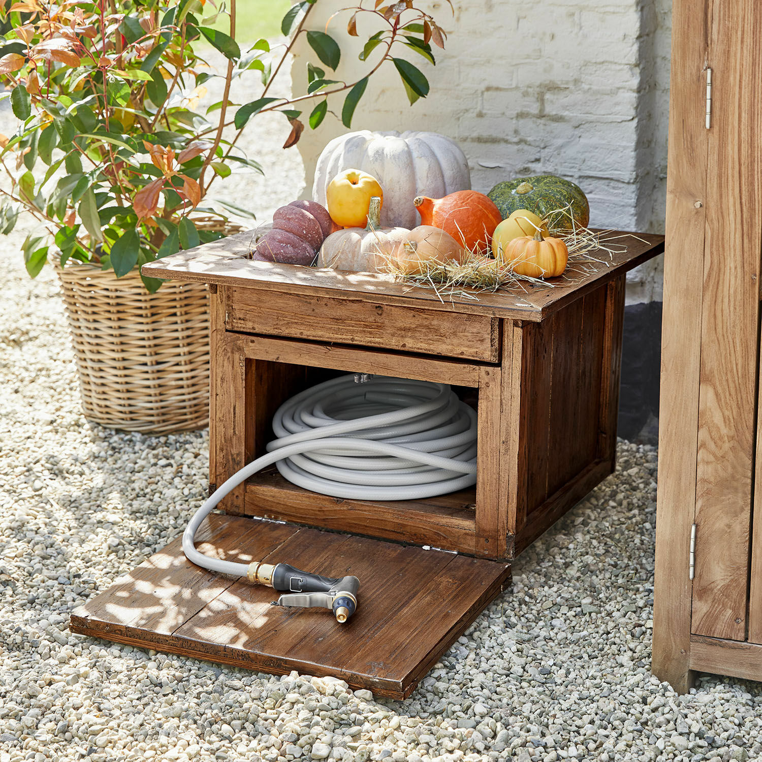 Vaso portatubo da giardino Fontabre Cassapanca da giardino in legno con tubo da giardino grigio e zucche decorative sopra